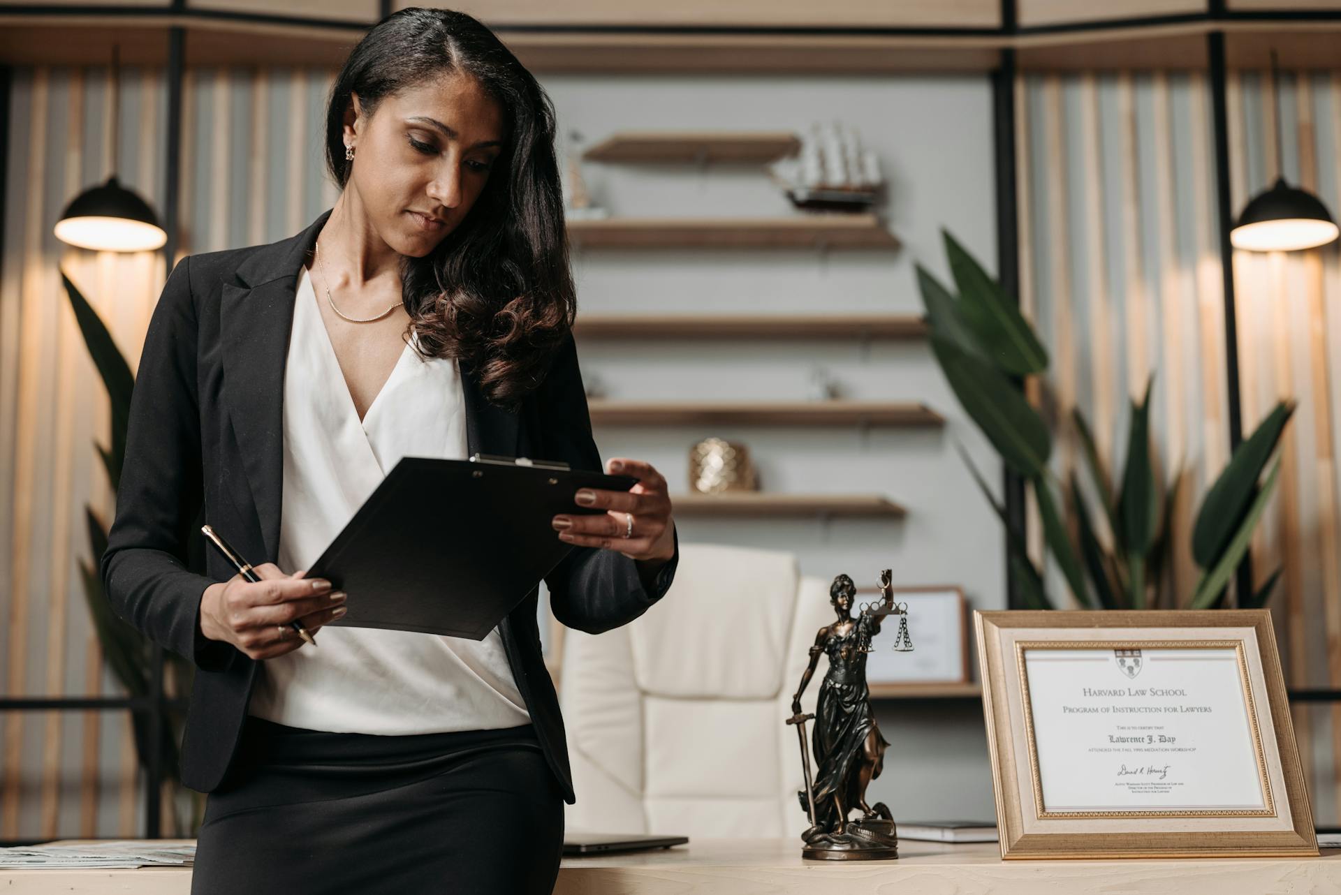 A businesswoman looking at documents on a clipboard | Source: Pexels
