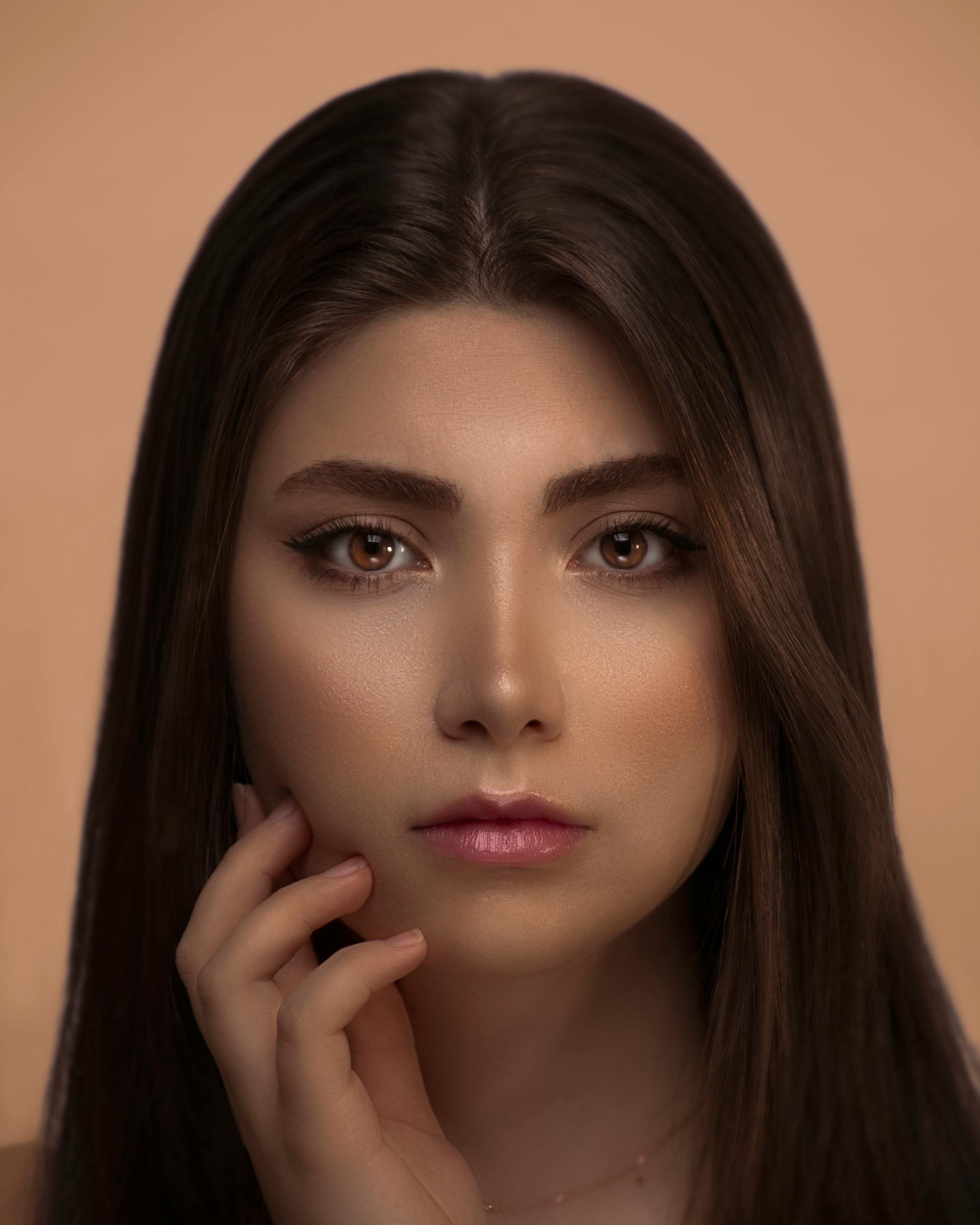 A woman touching her face with one hand | Source: Pexels