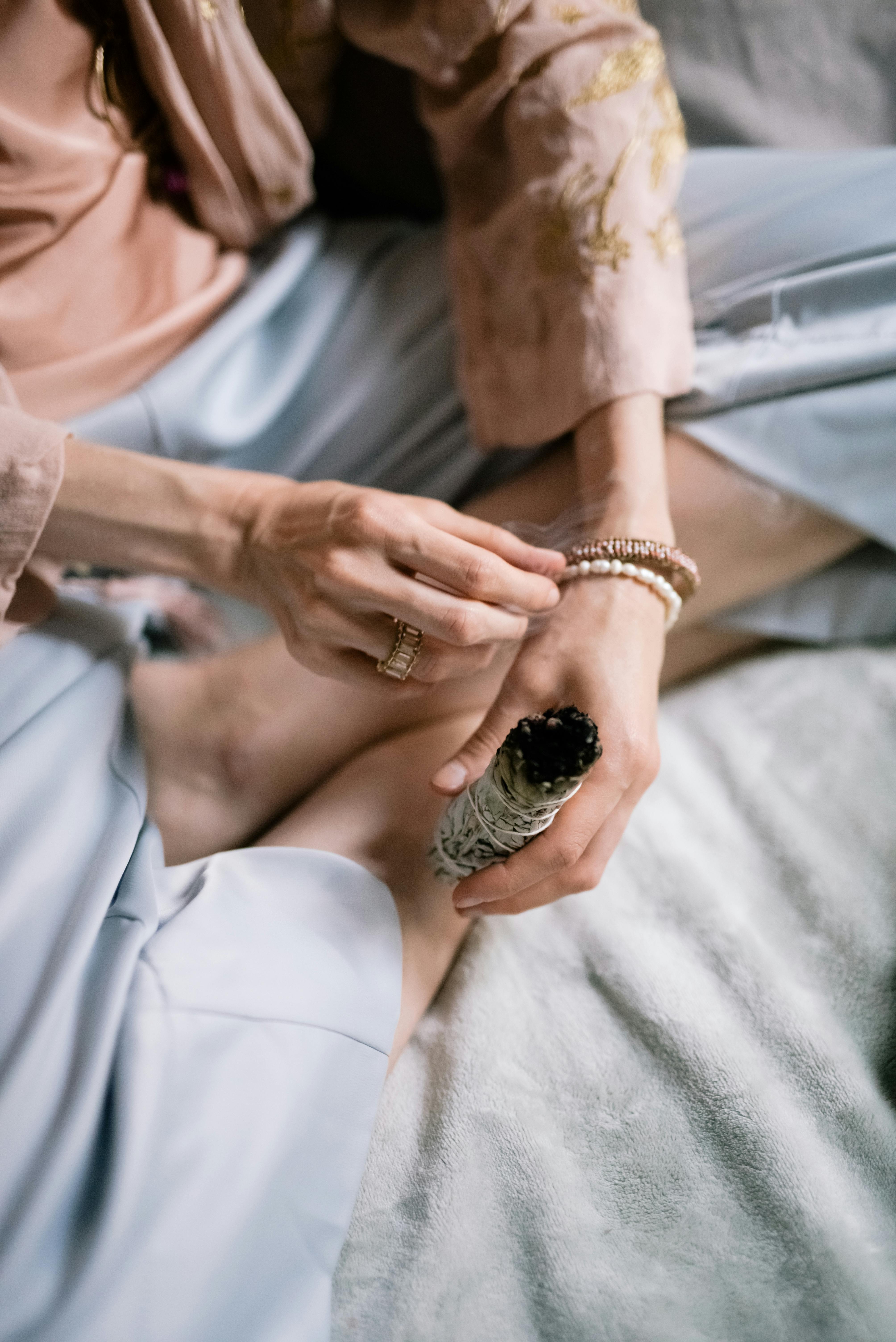 A woman smudging a bedroom | Source: Pexels