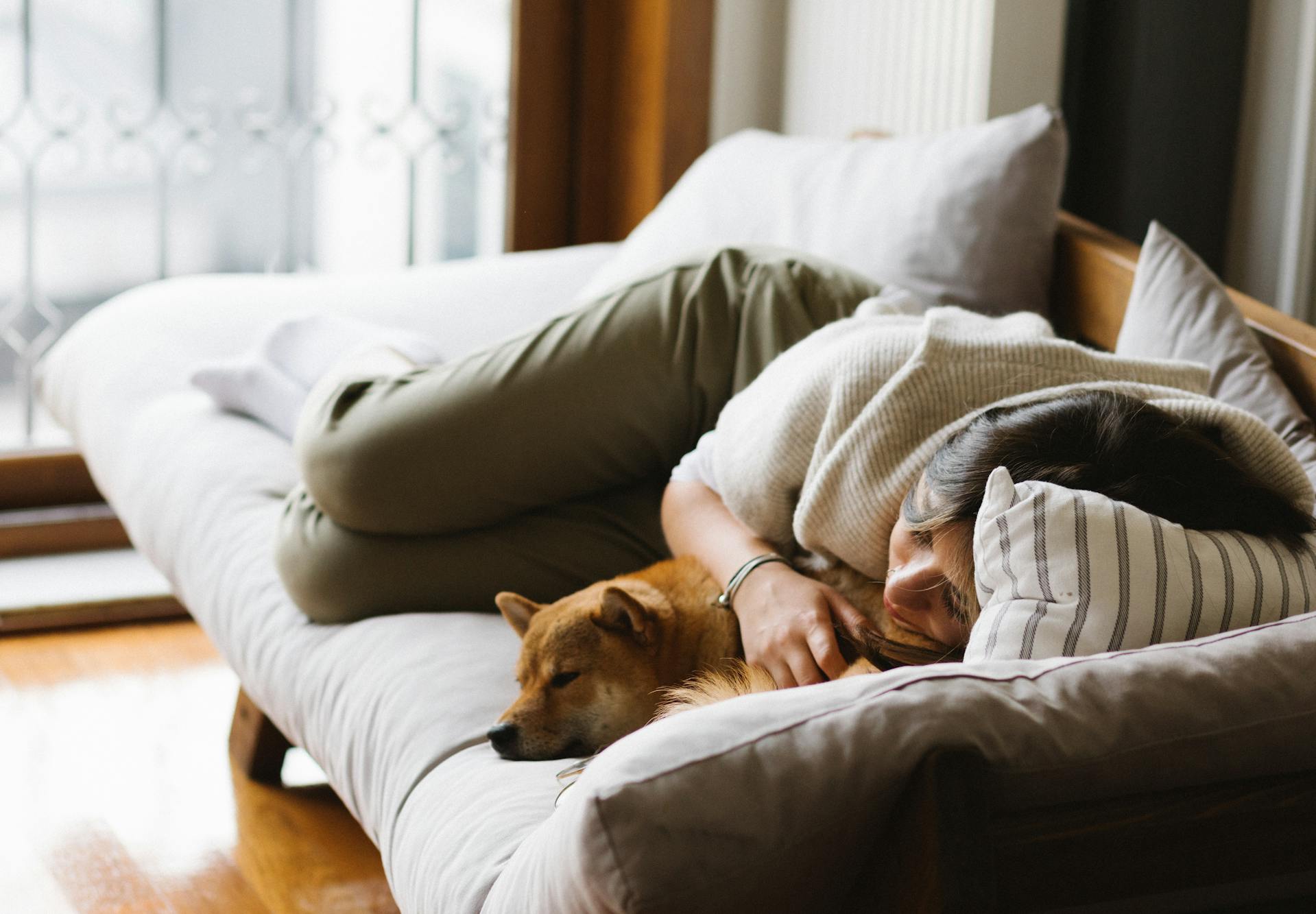 A woman curled up on a sofa | Source: Pexels