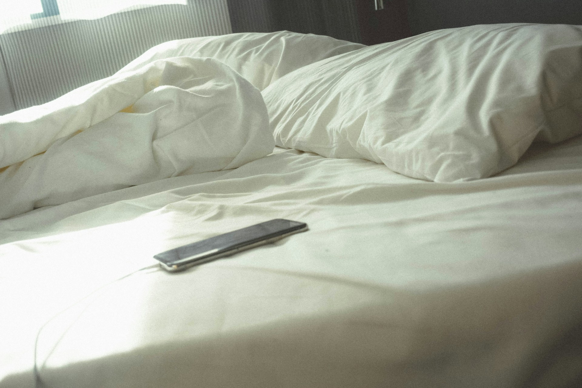 A phone on the bed | Source: Unsplash