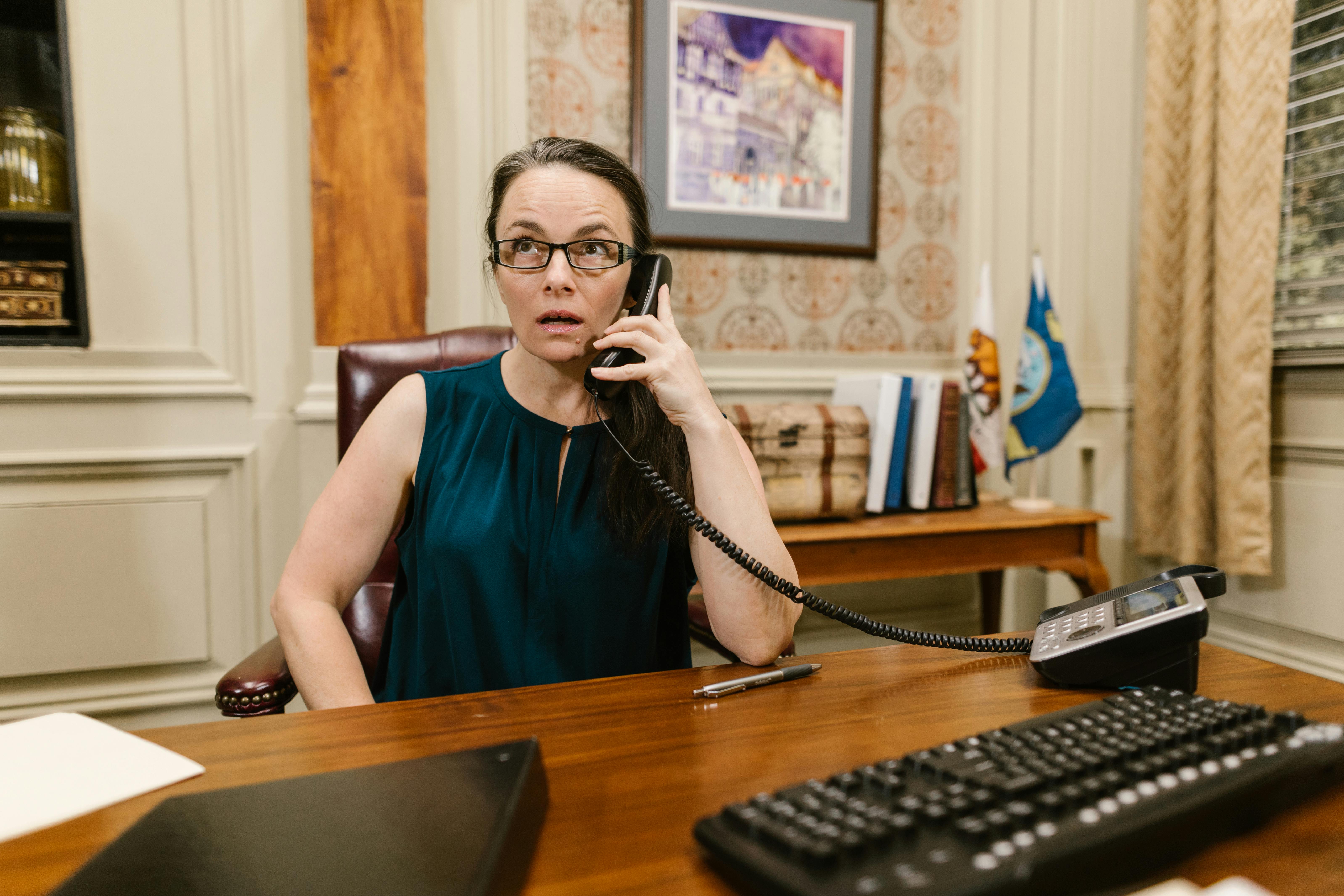 A woman in an office, on the telephone | Source: Pexels