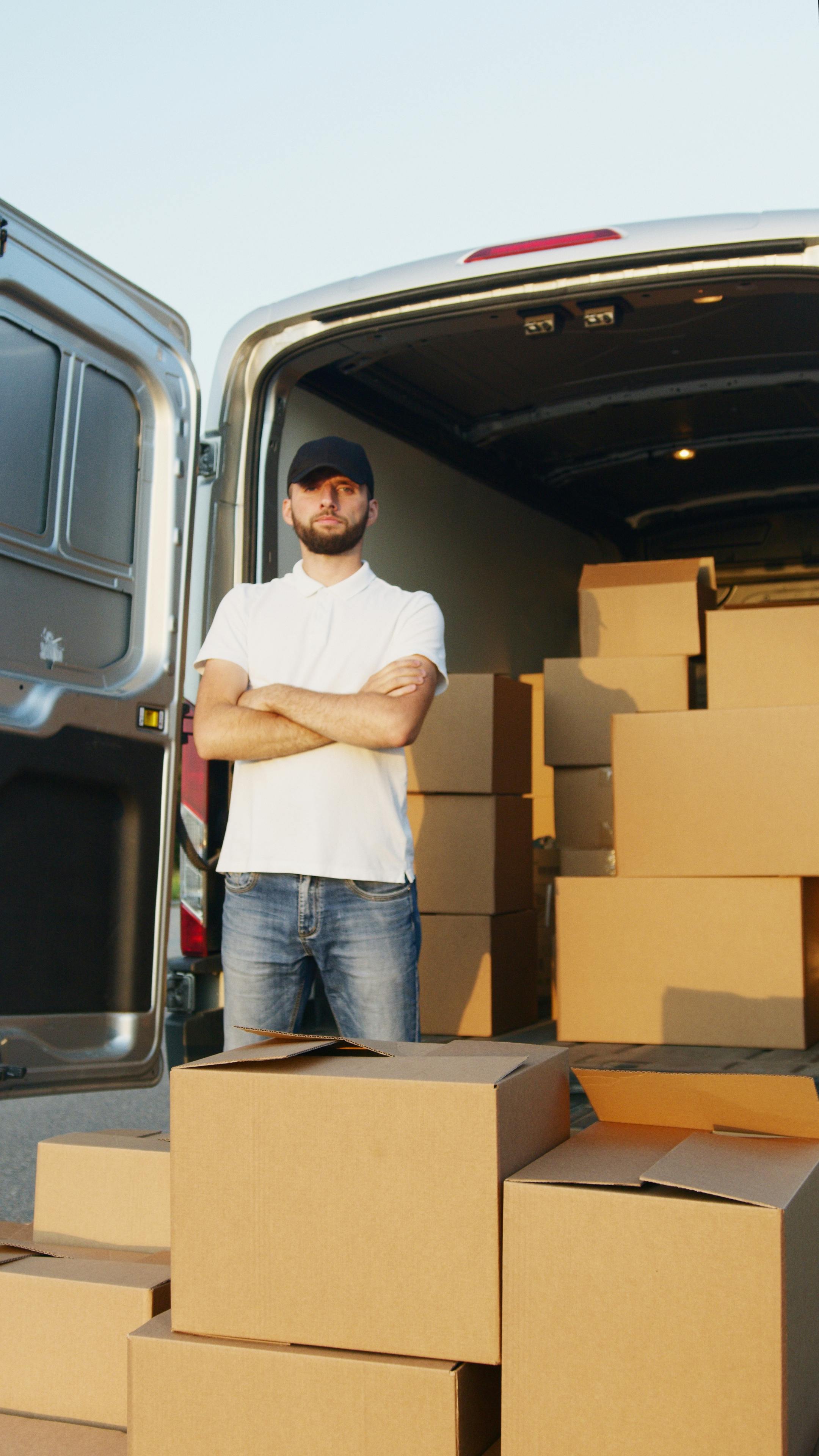 A man pictured alongside cardboard boxes | Source: Pexels