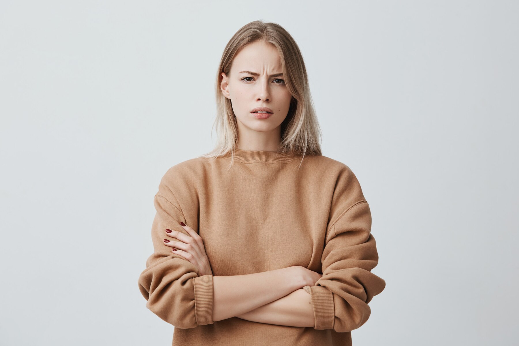 A serious woman with her arms crossed | Source: Freepik