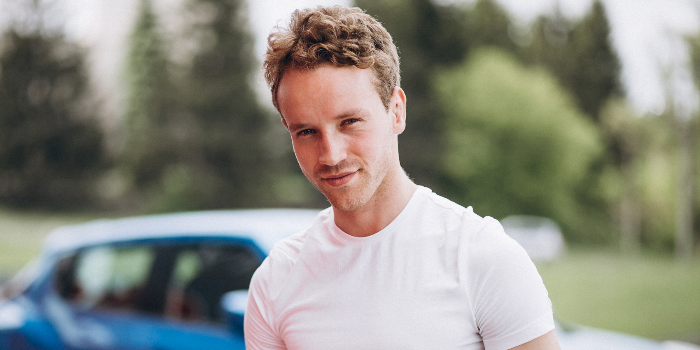 A young man standing in front of a car | Source: Freepik