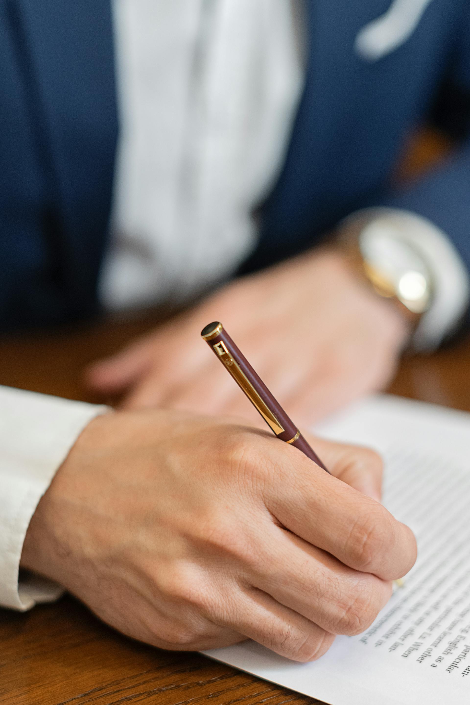 A close-up shot of a person signing a document | Source: Pexels