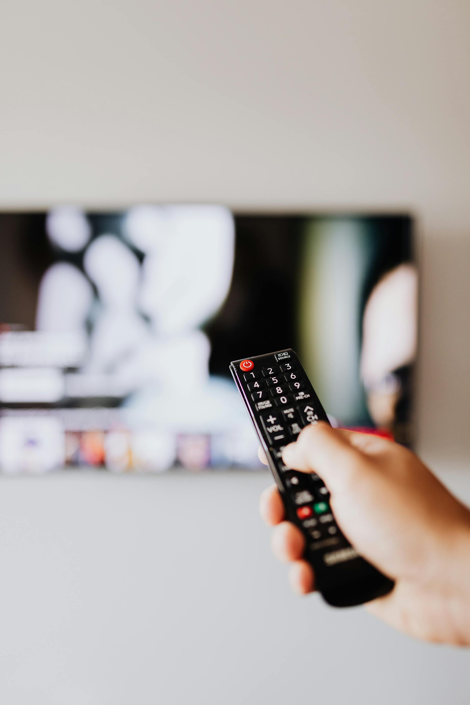 A person holding a TV remote | Source: Pexels