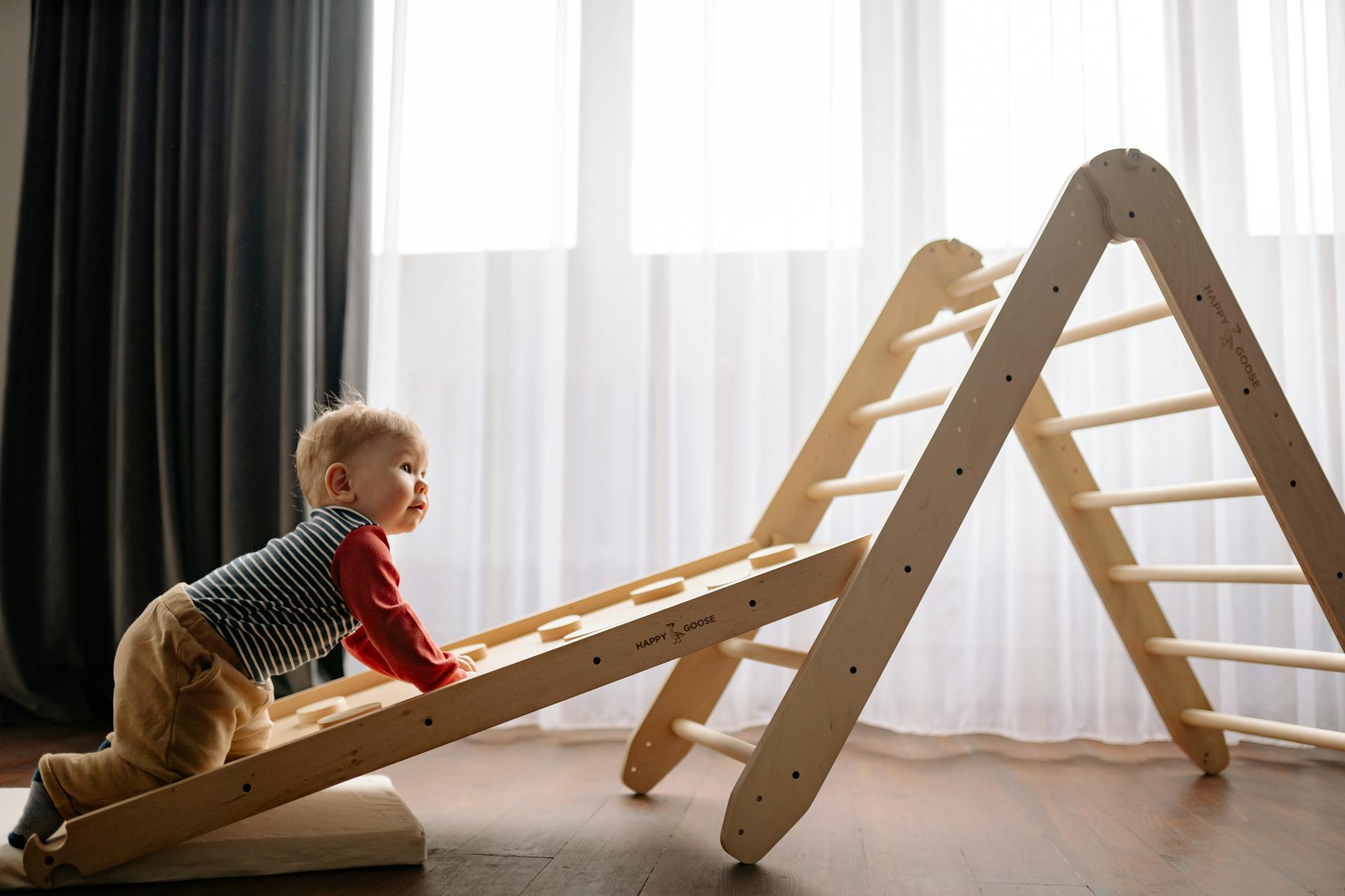 A little boy climbing a wooden ladder | Source: Pexels