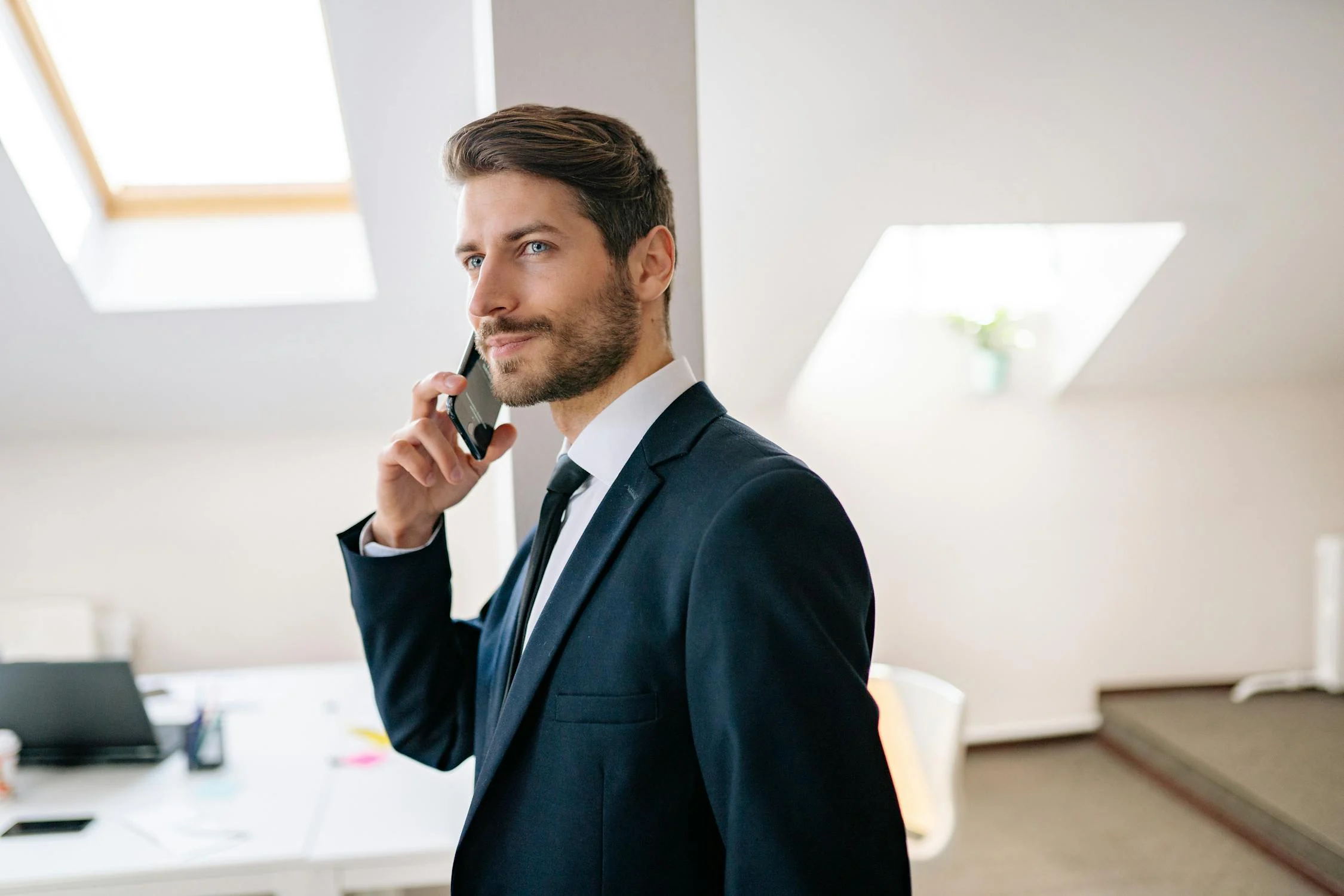 A man talking on his phone in his office | Source: Pexels