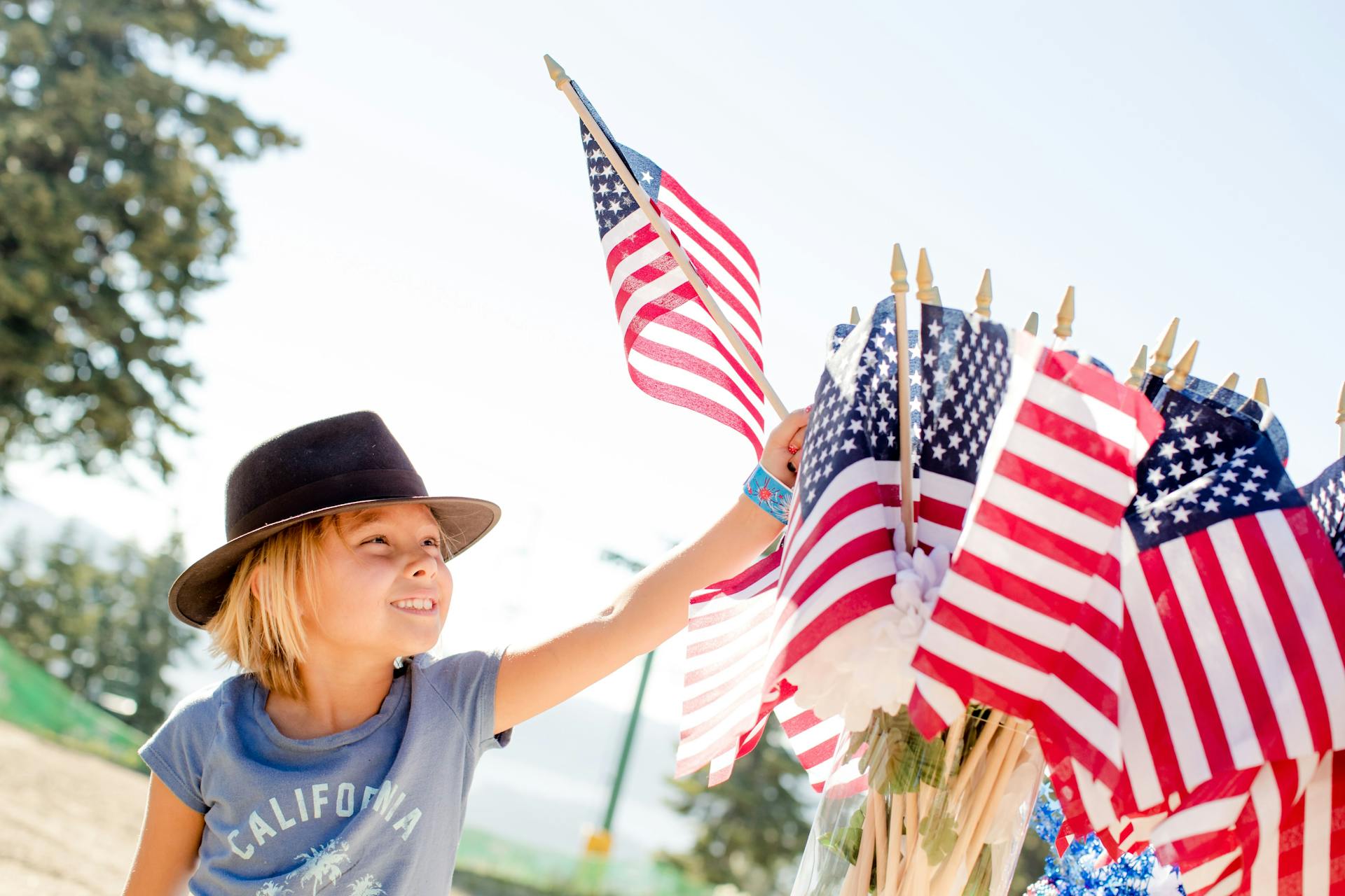 A young boy holding a USA flag | Source: Pexels