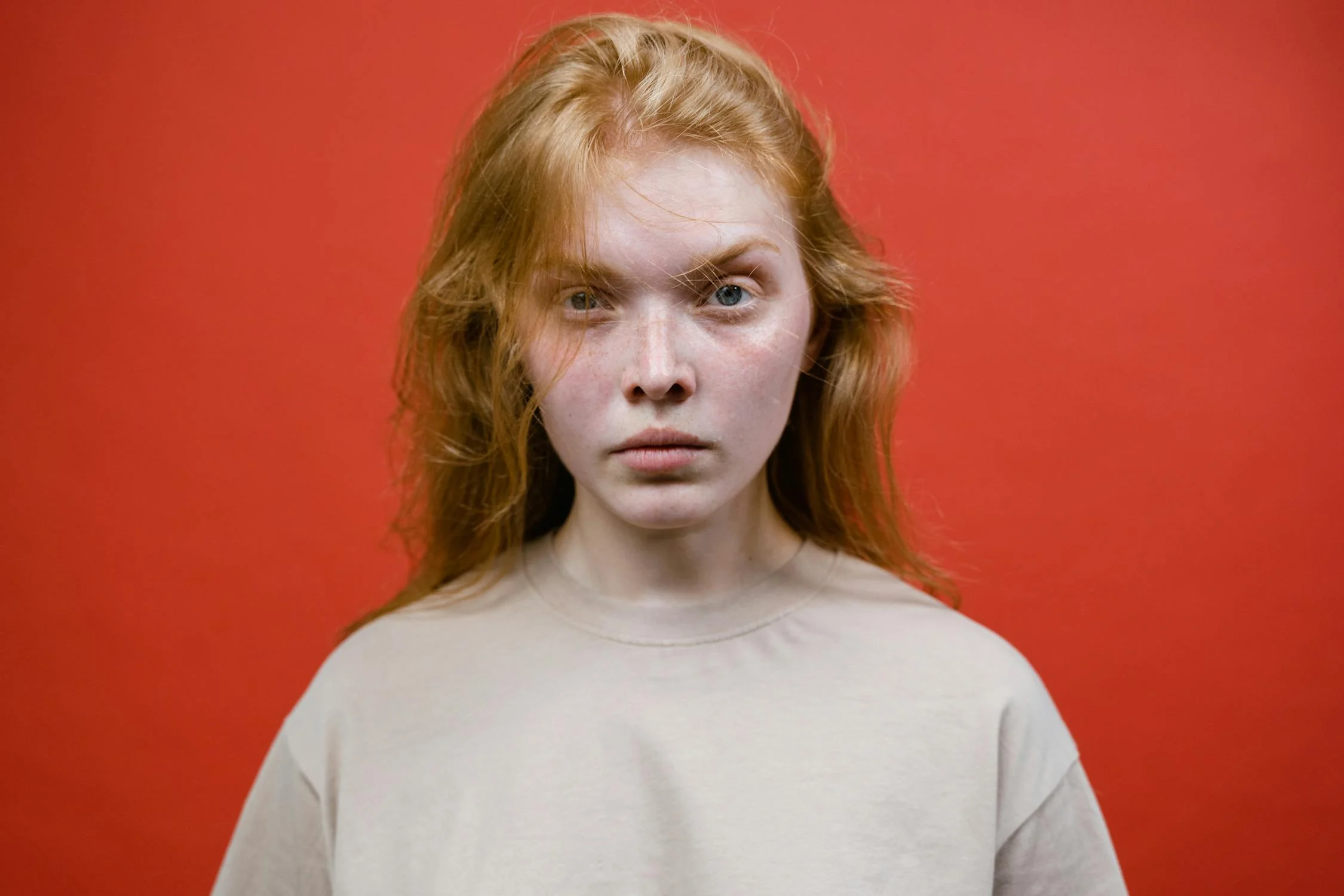 An angry woman against a red backdrop | Source: Pexels