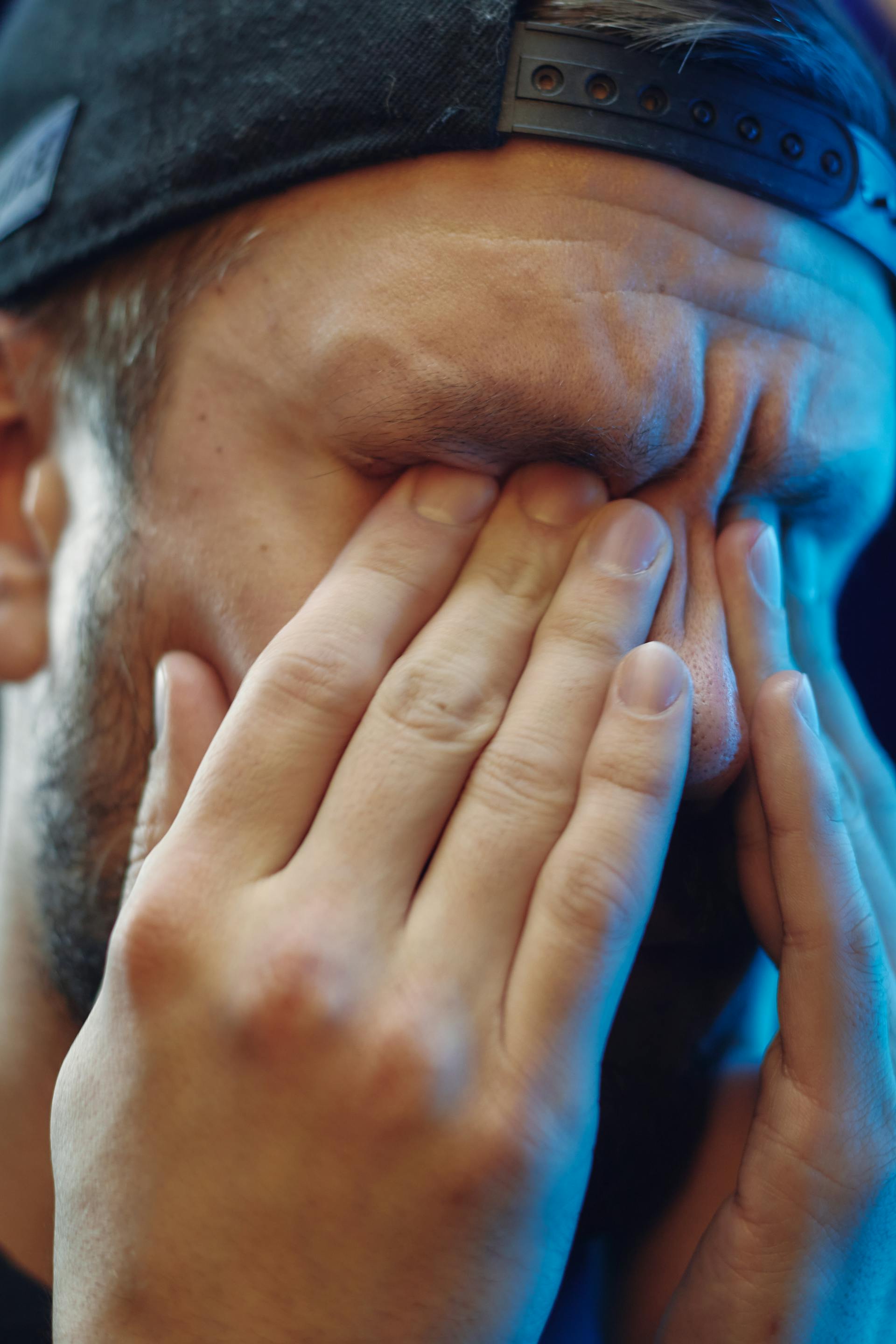 A distressed man covering his face with his hands | Source: Pexels