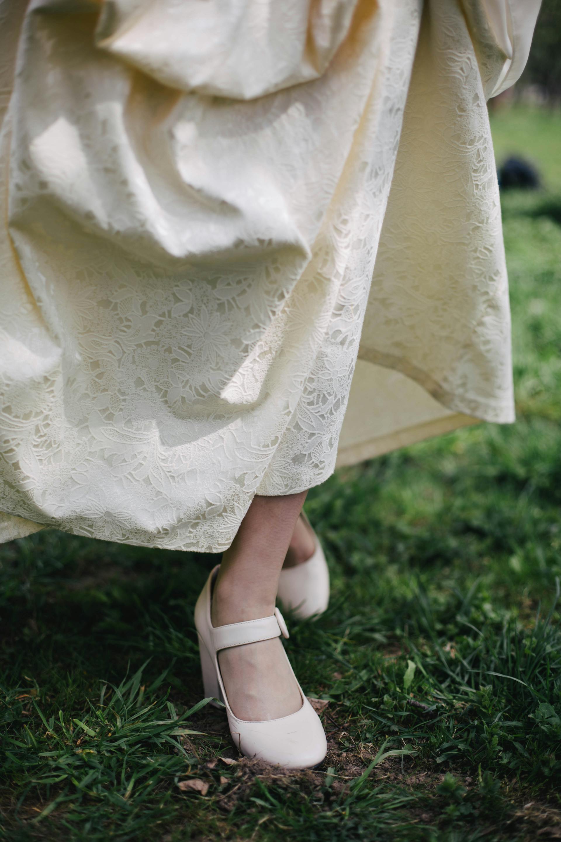 A person in a cream-colored dress walking through grass | Source: Pexels