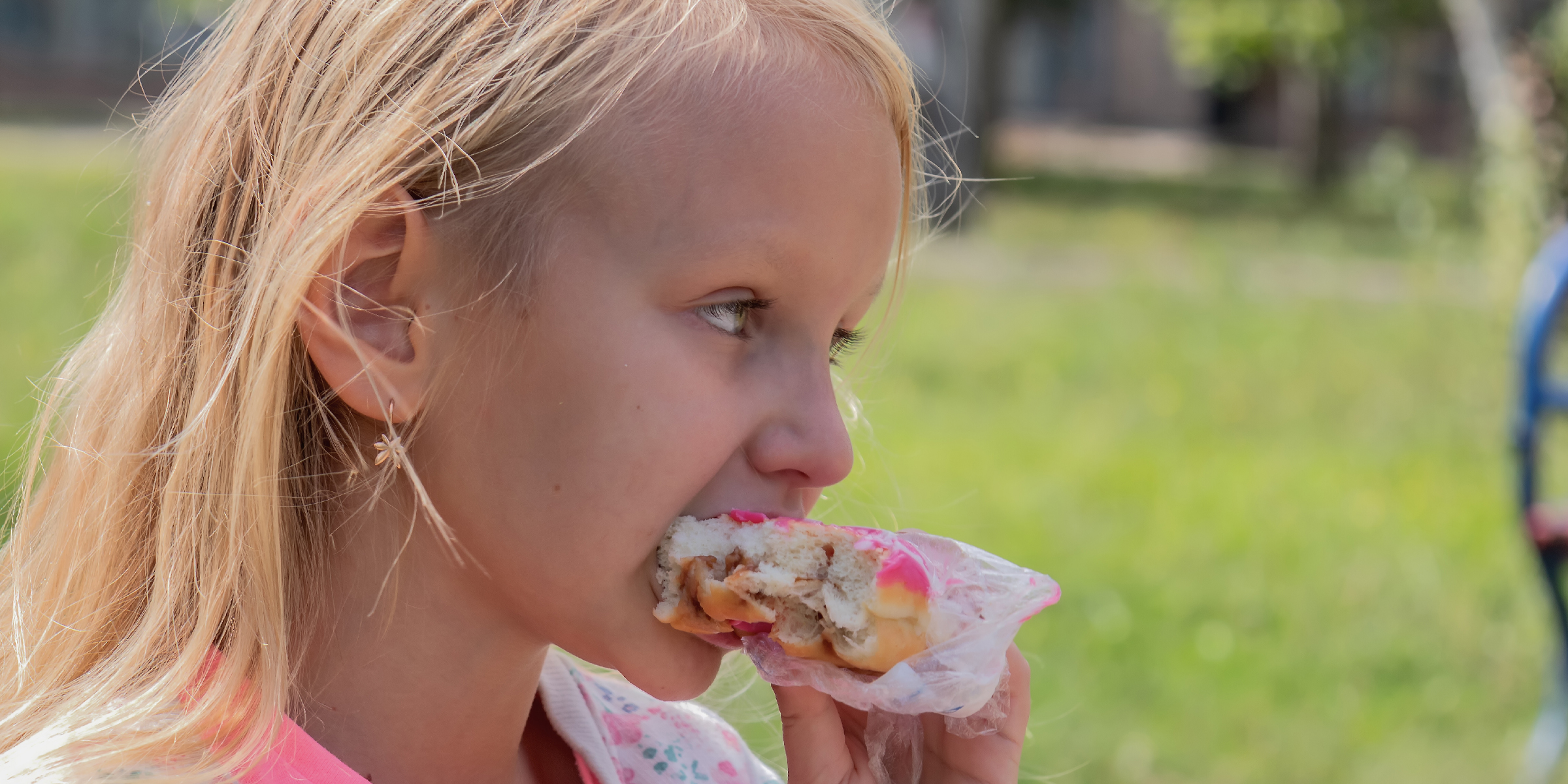 A little girl eating a donut | Source: Shutterstock