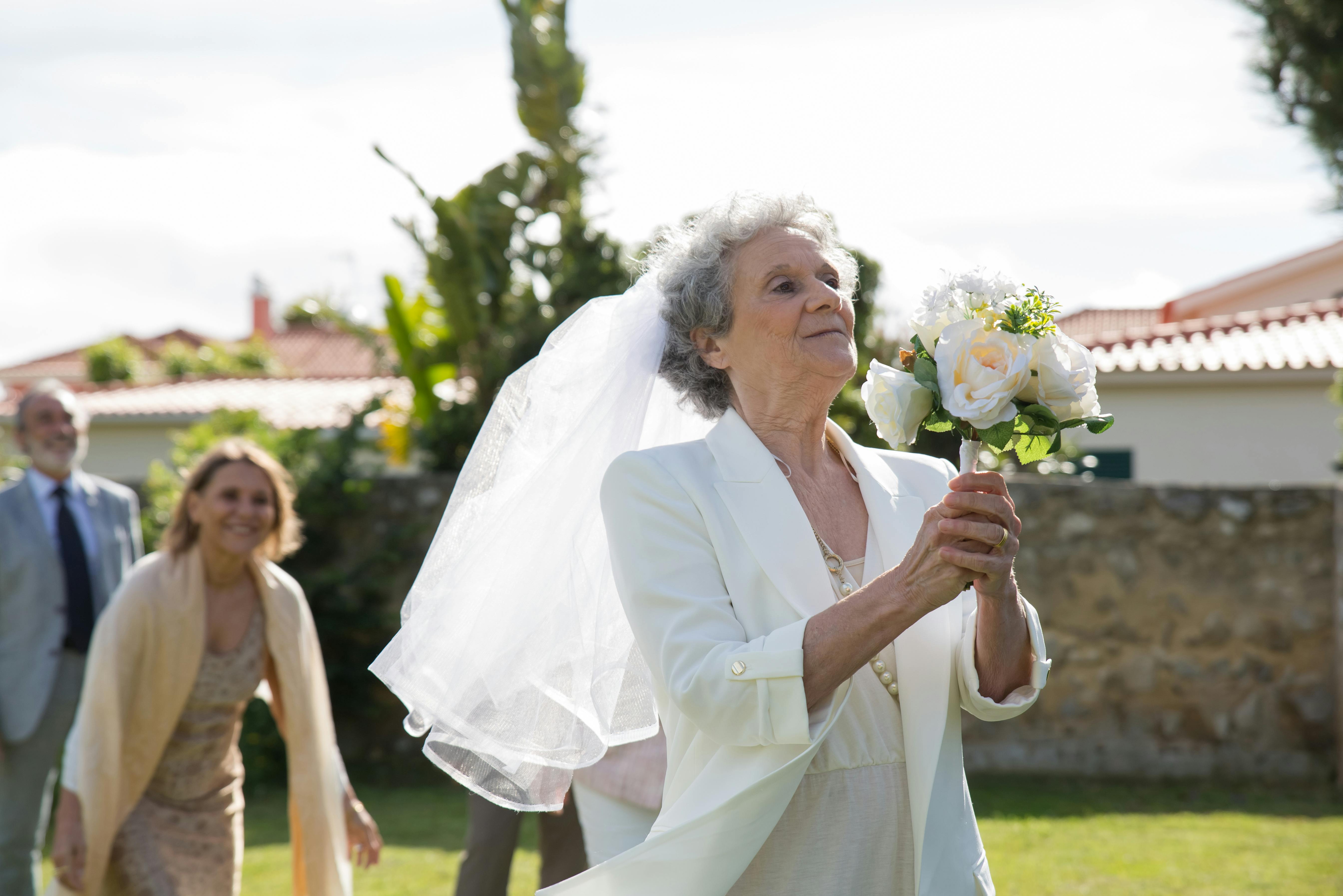 Elderly woman ready to toss her wedding bouquet | Source: Amomama