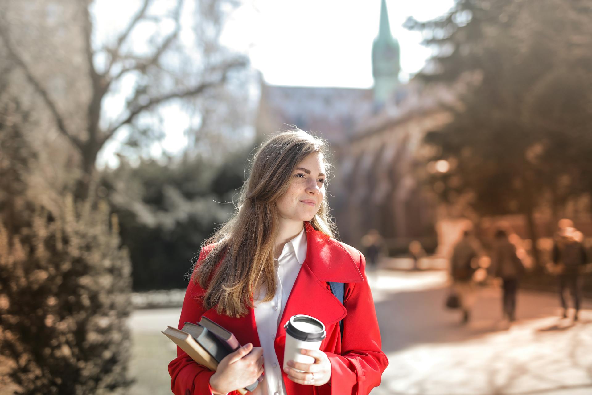 A woman on a college campus carrying books | Source: Pexels