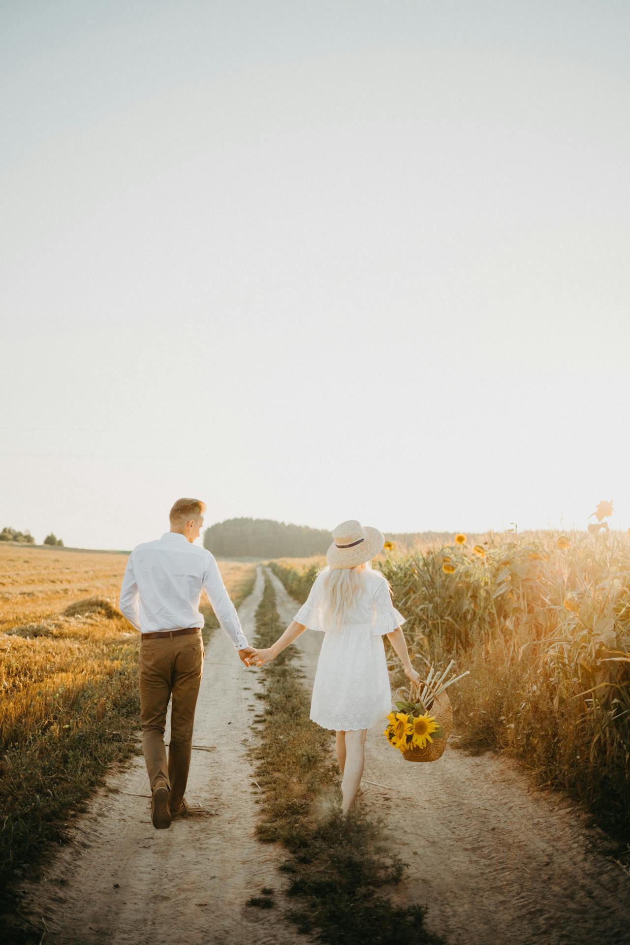 A woman holding a basket of sunflowers and walking with a man | Source: Pexels