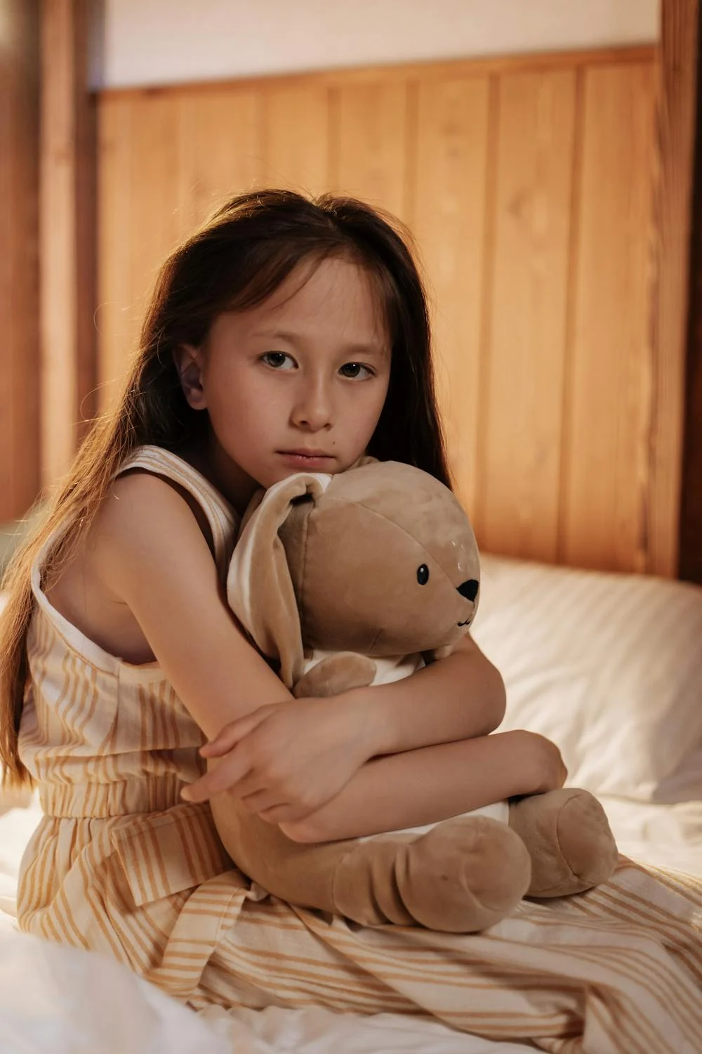 A sad girl hugging her toy | Source: Pexels