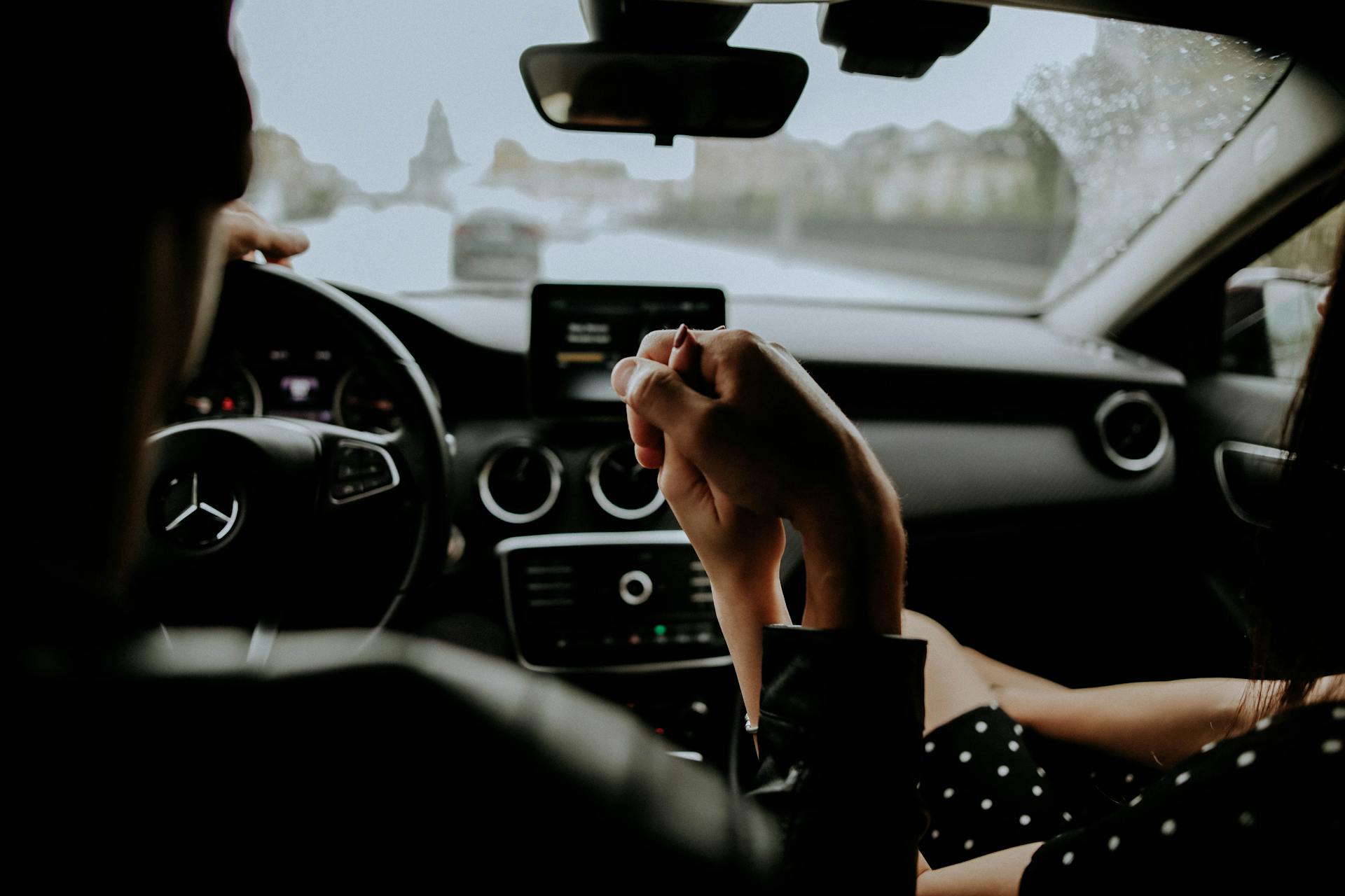 A couple holding hands inside a car | Source: Pexels