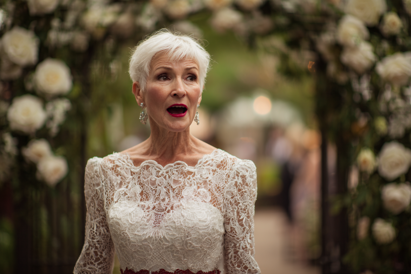 A woman in a white lace dress staring at someone in shock | Source: Midjourney
