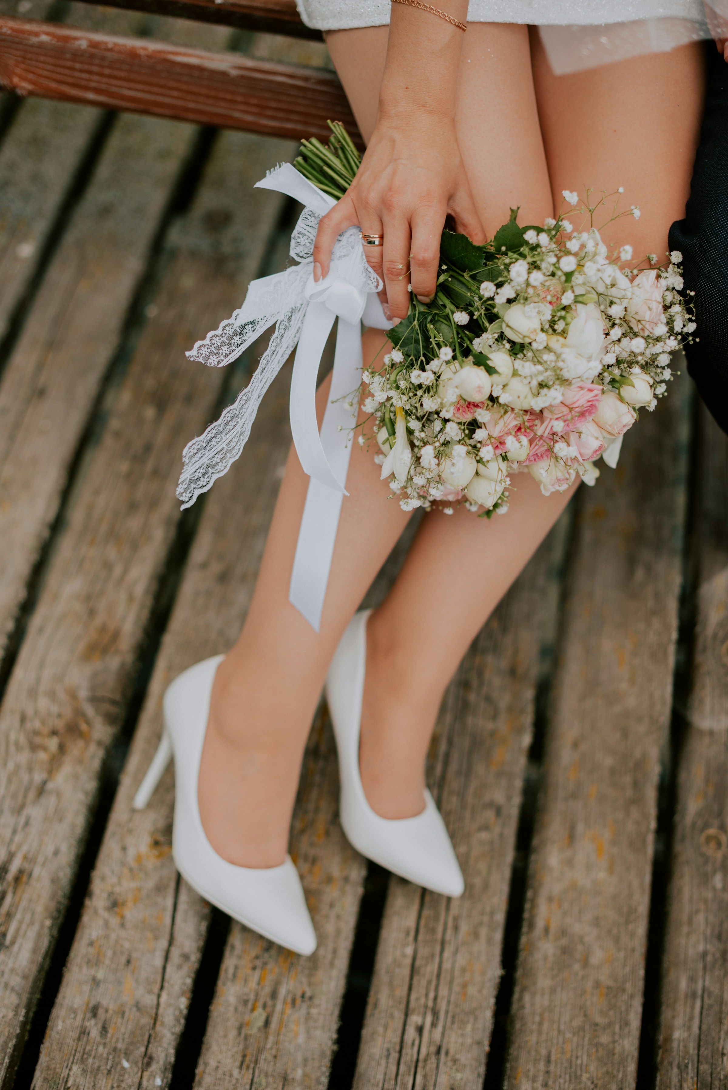 A bride in white heels holding flowers | Source: Unsplash