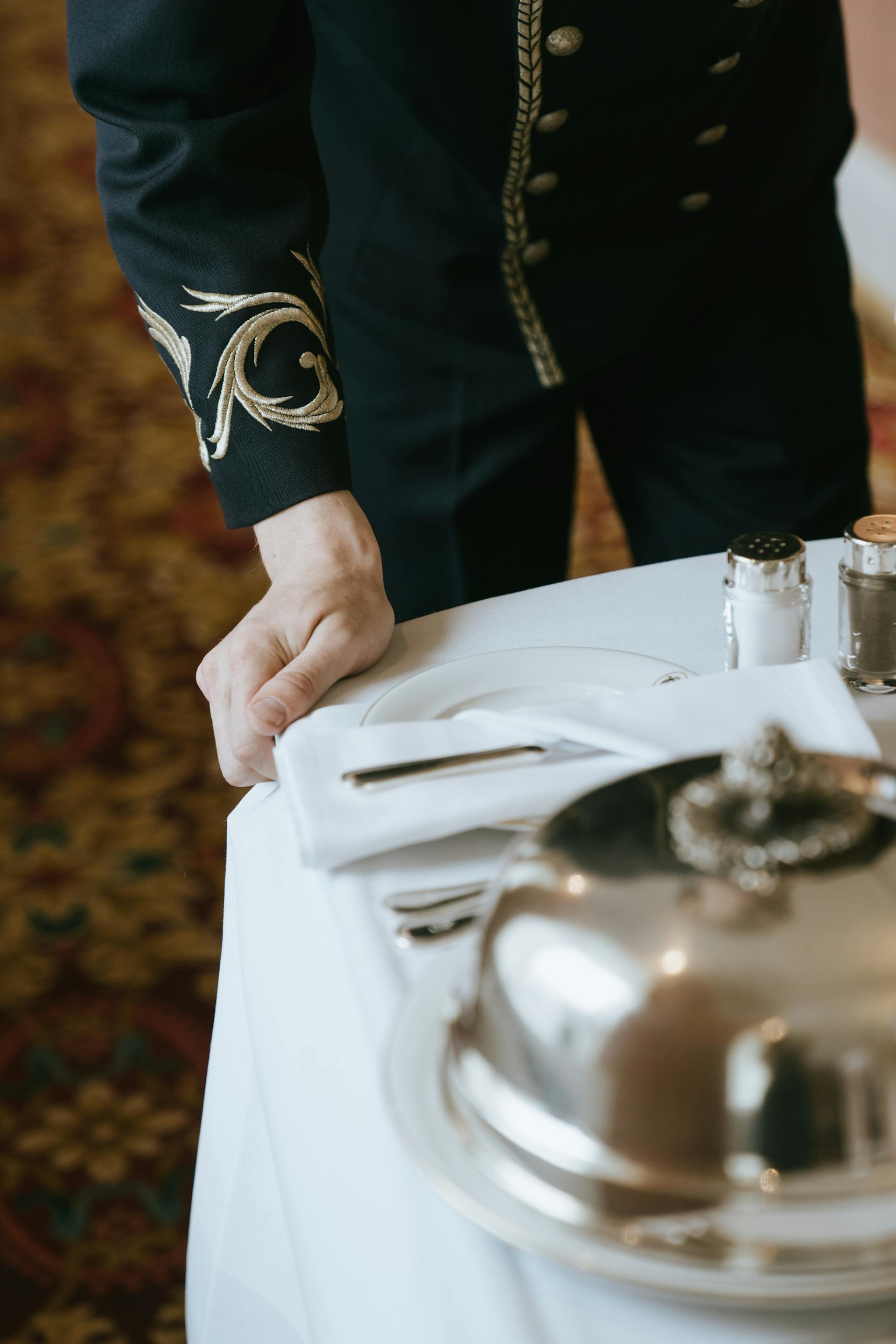 Cropped shot of a butler pushing a serving tray | Source: Pexels