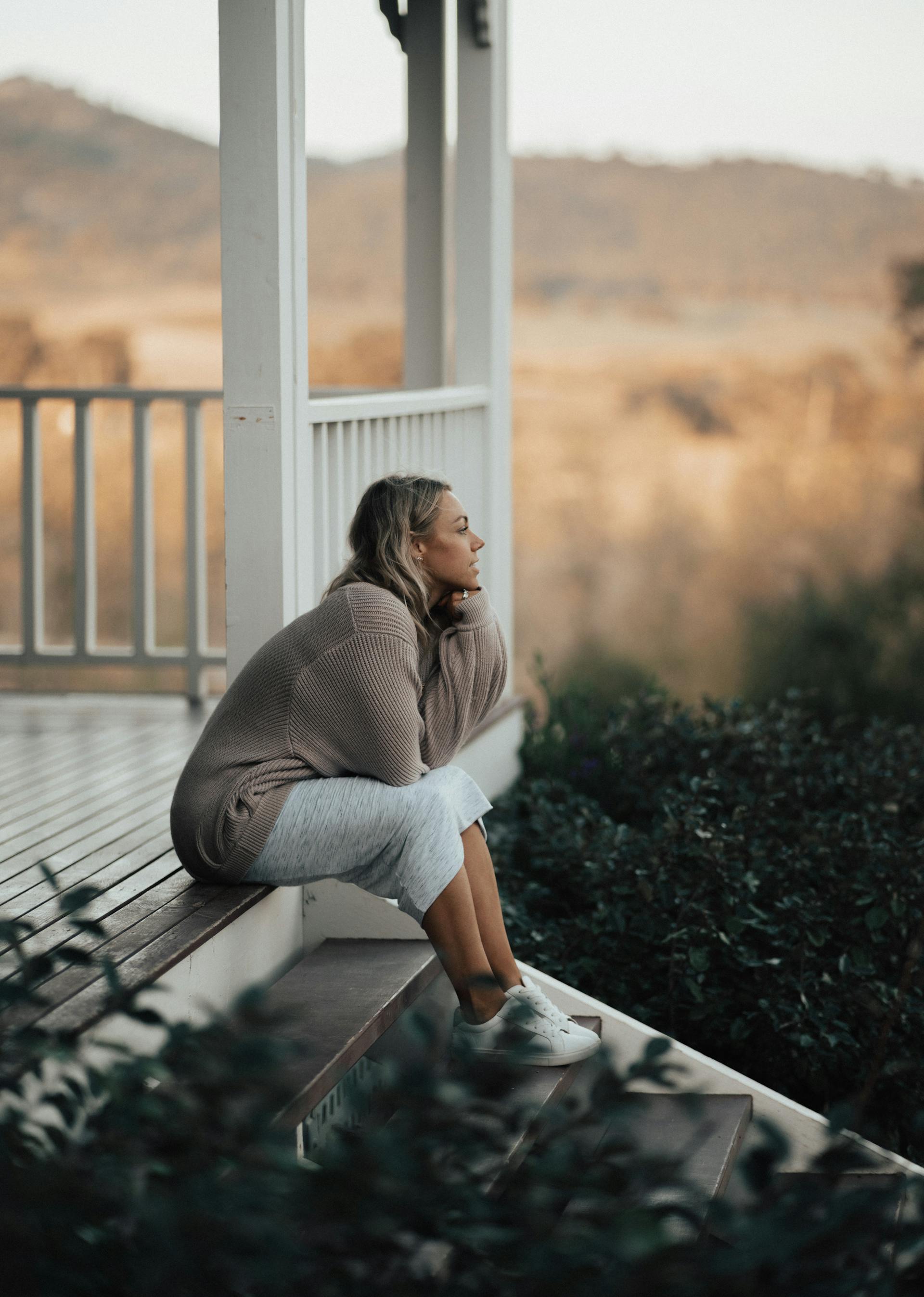 A woman sitting on a porch | Source: Pexels