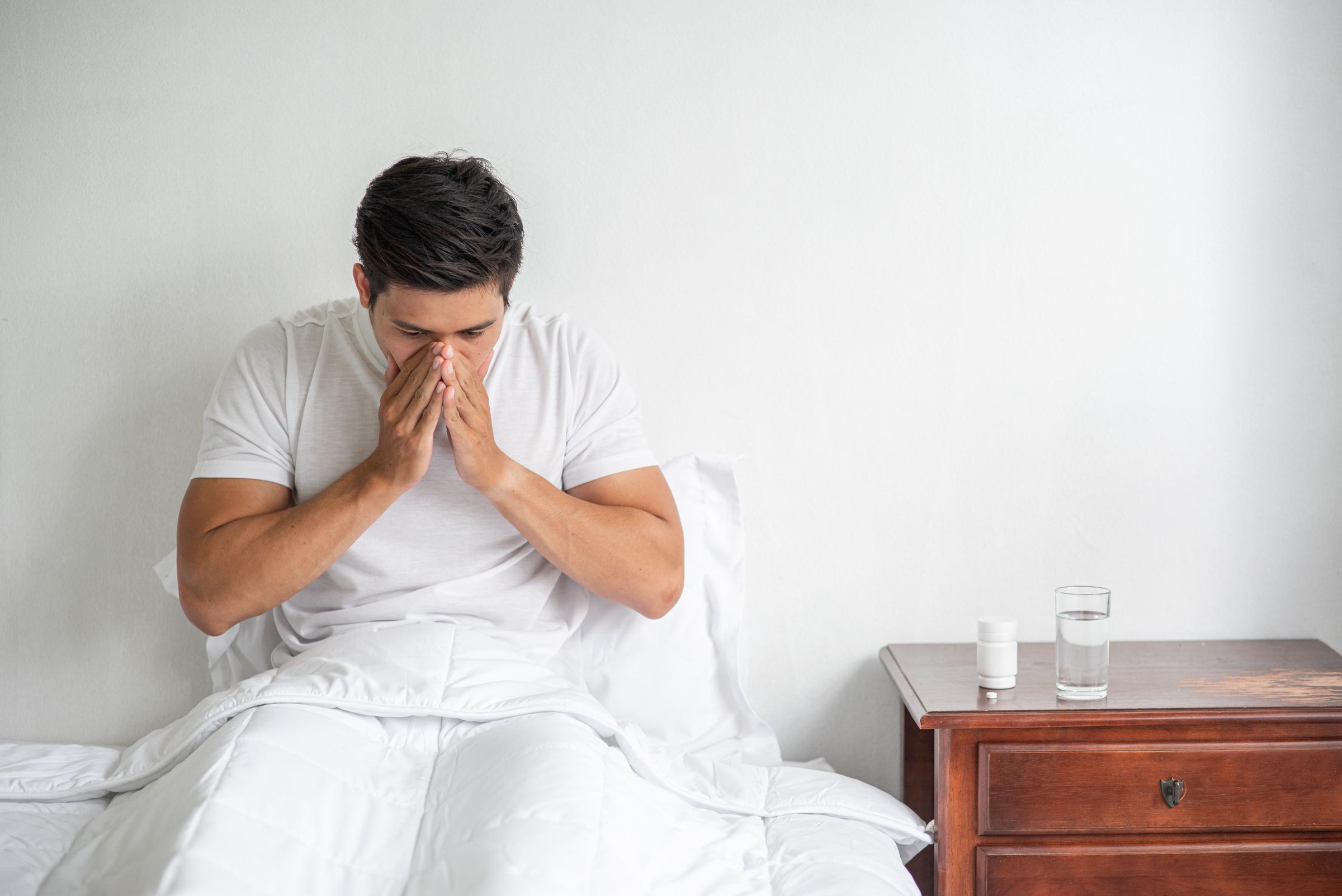 A distressed man sitting on the bed | Source: Freepik