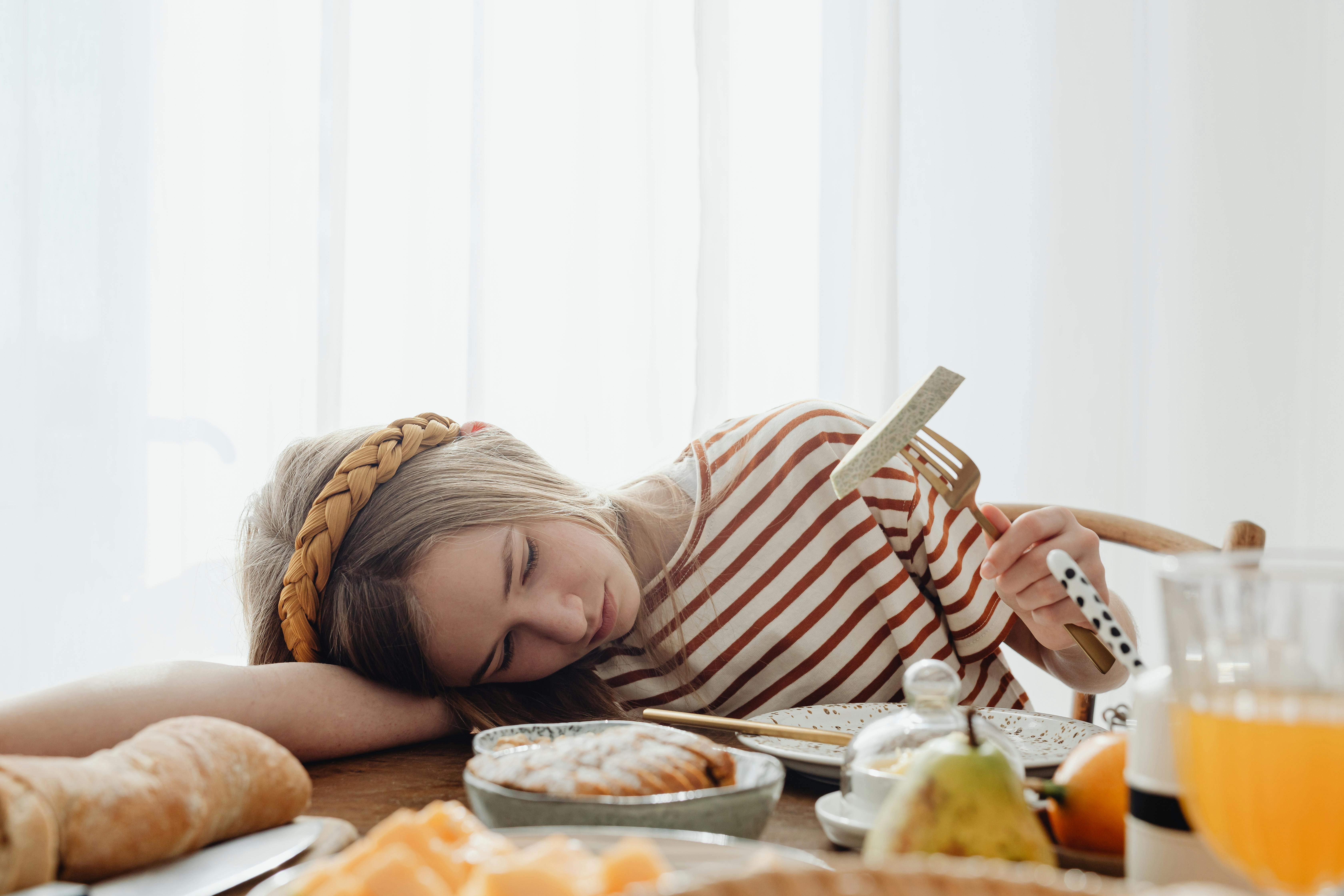A sad teenage girl at the breakfast table | Source: Pexels