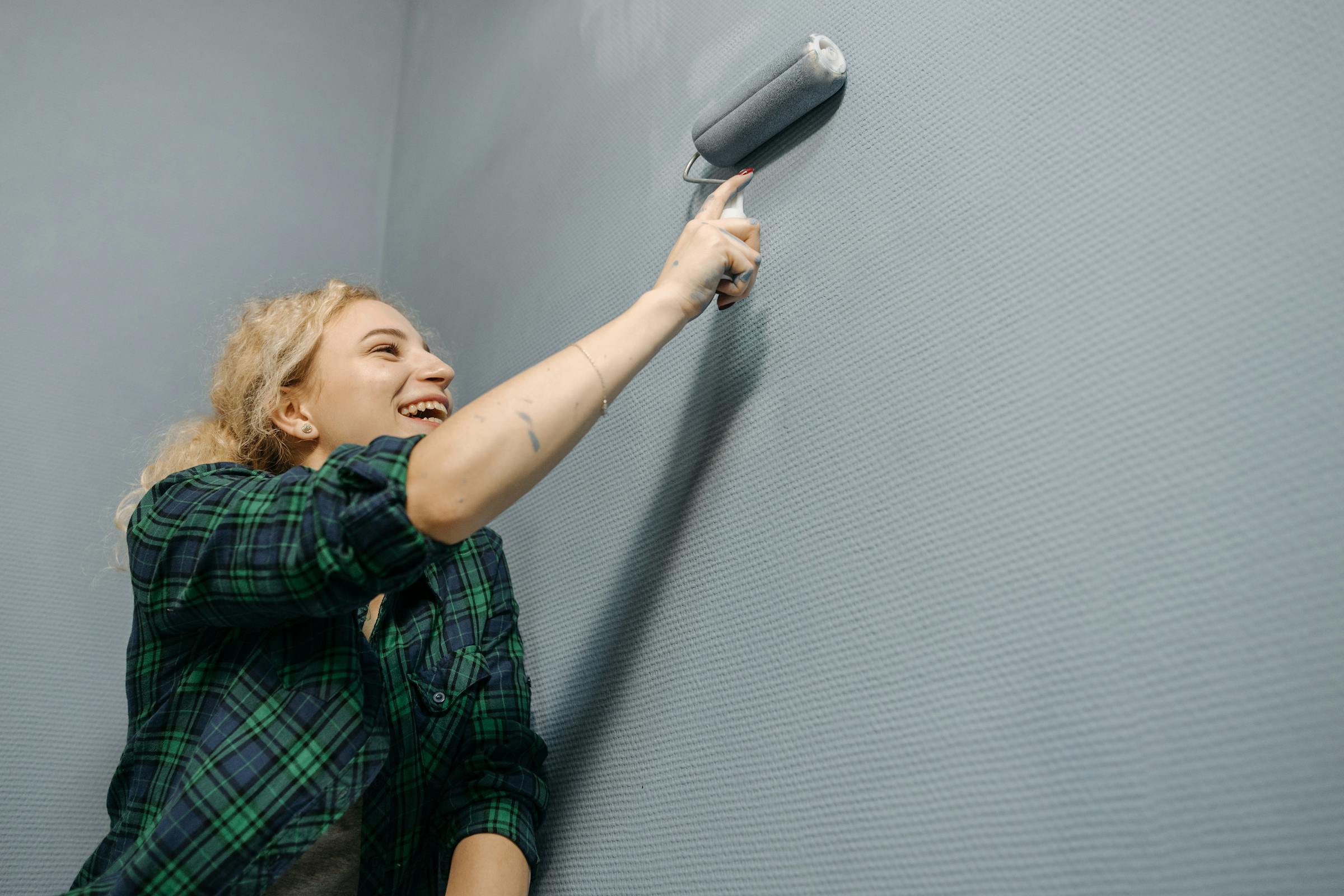 A woman painting a wall | Source: Pexels