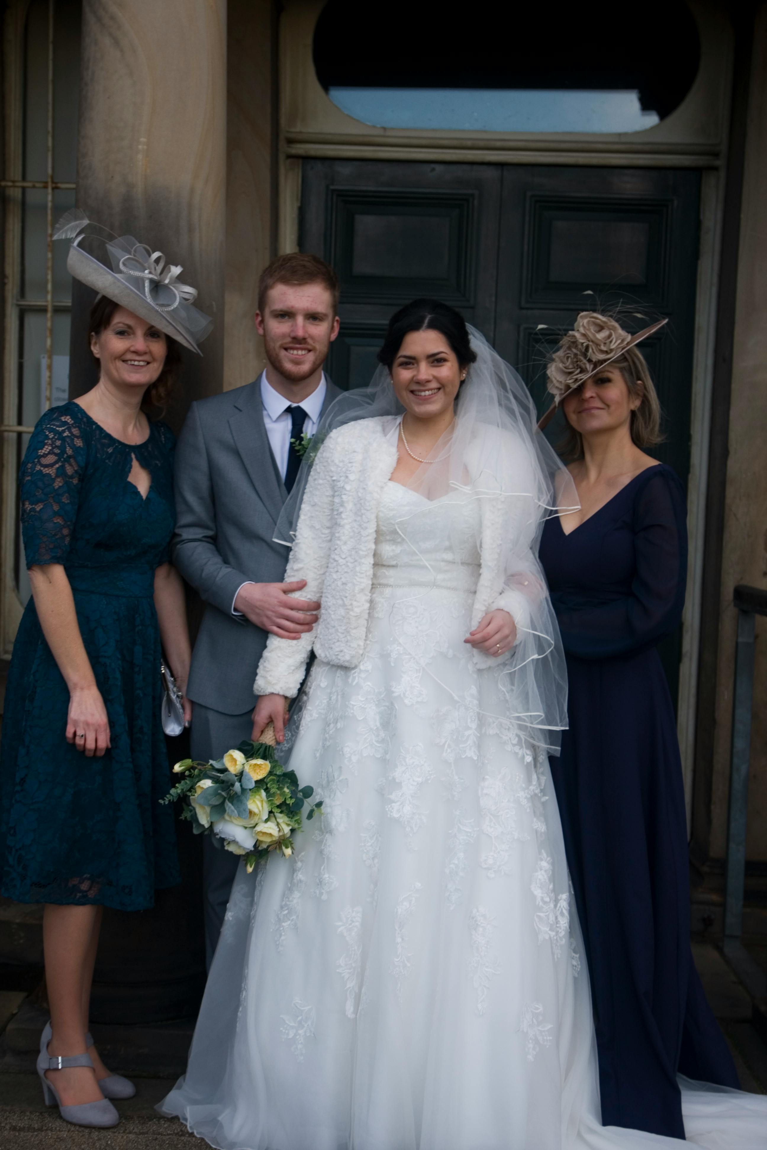 Bride and groom posing with their mothers | Source: Pexels