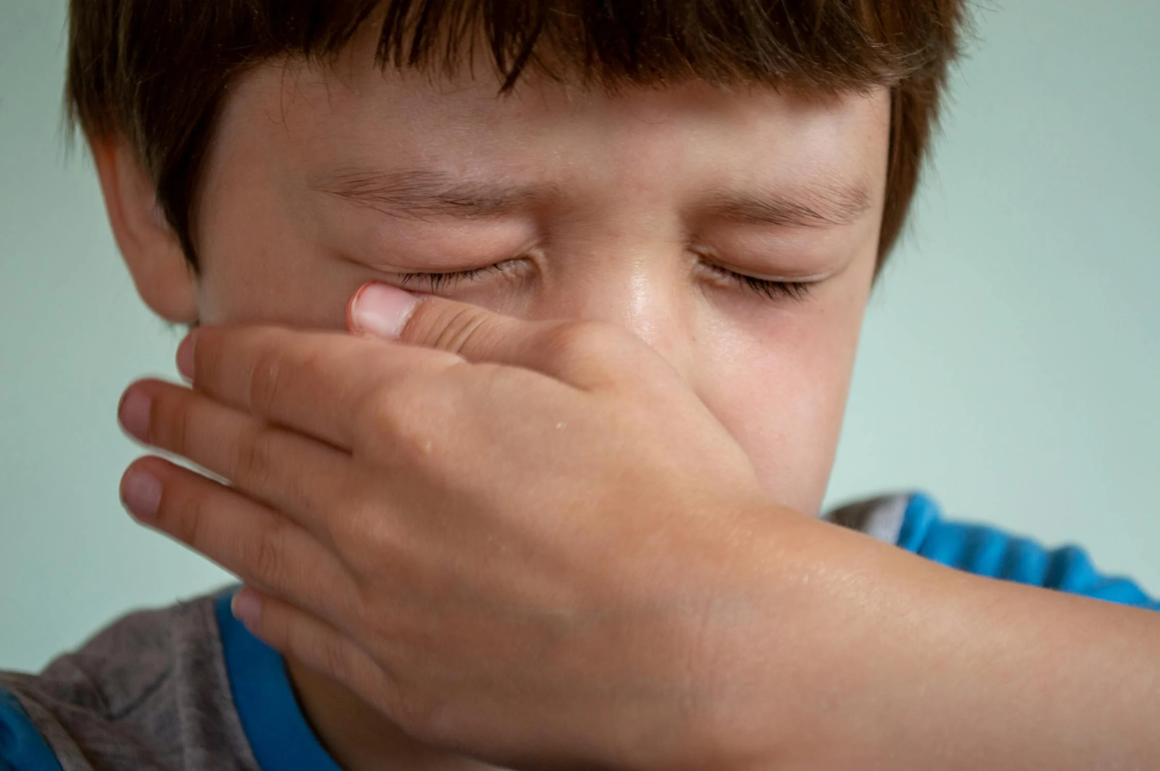 A sad boy wiping his face | Source: Pexels