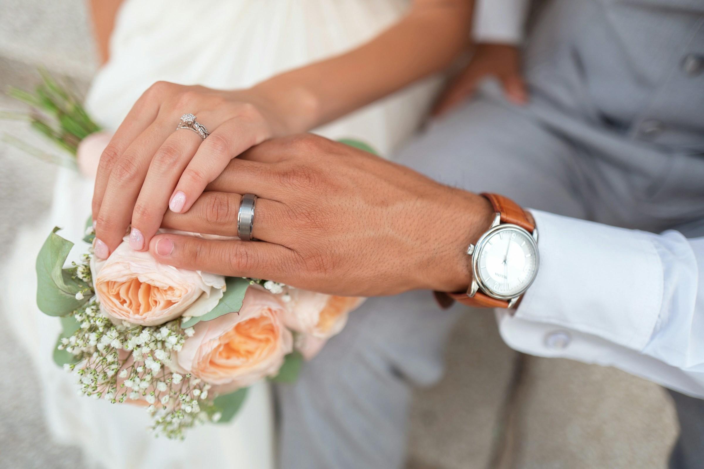 A couple touching a bouquet on their big day | Source: Unsplash