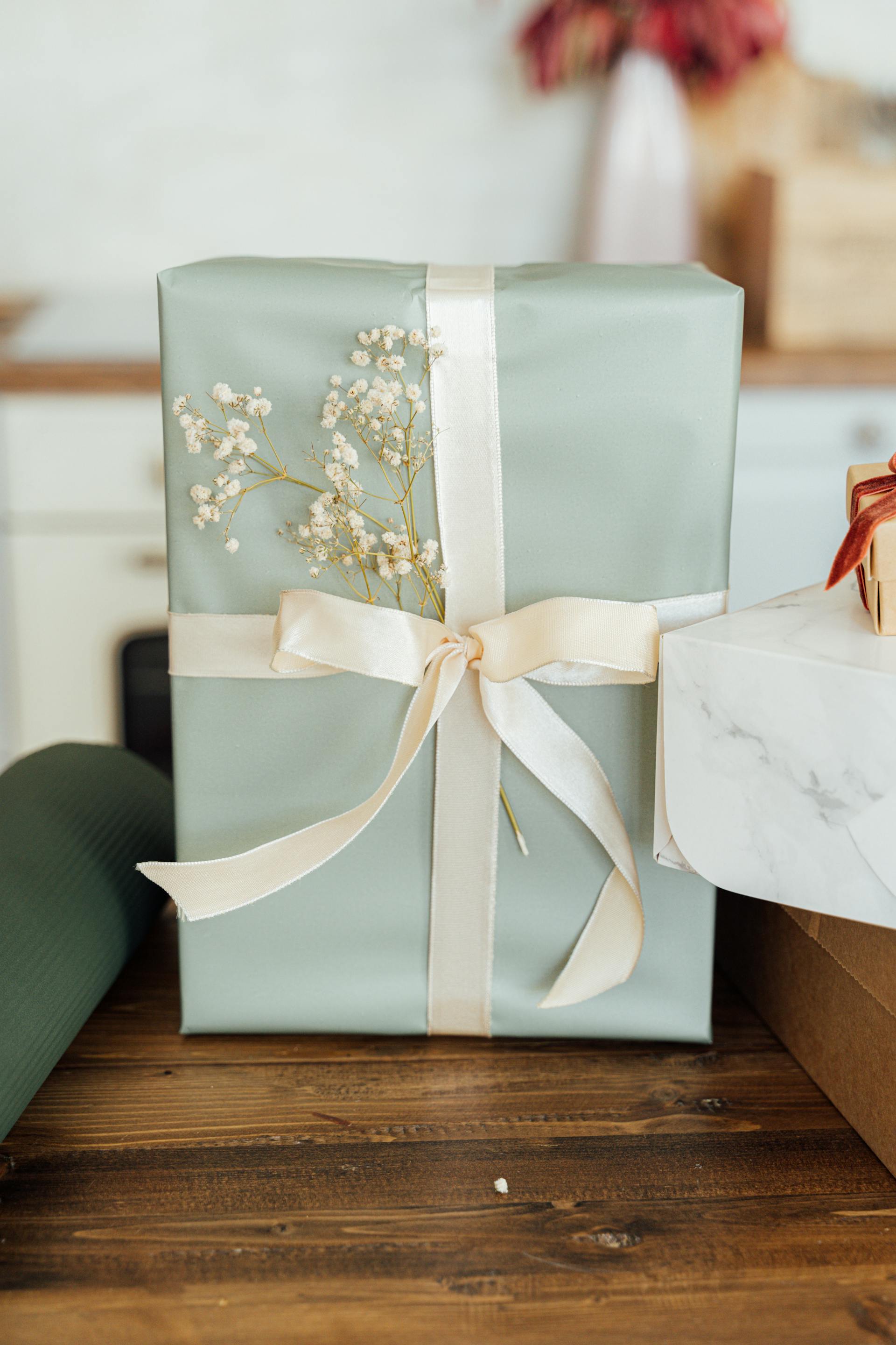 A present wrapped in paper with a ribbon and flowers | Source: Pexels
