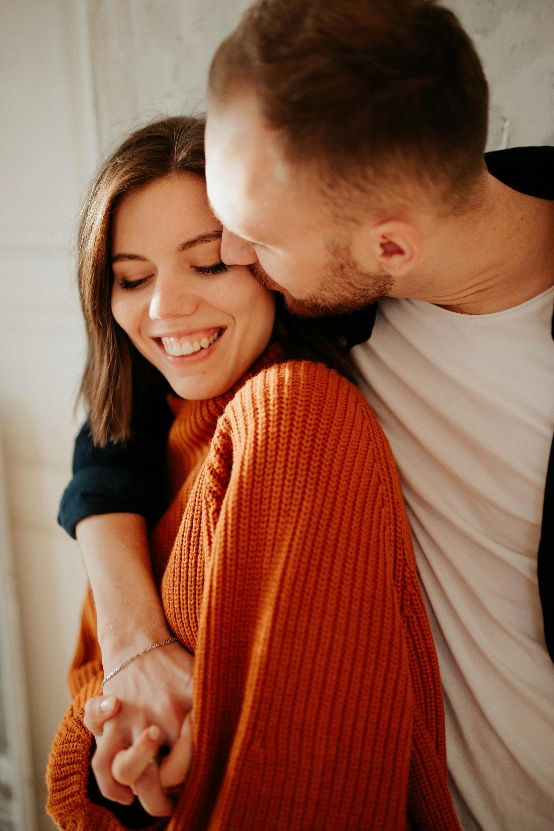 A man kissing and embracing his wife | Source: Pexels