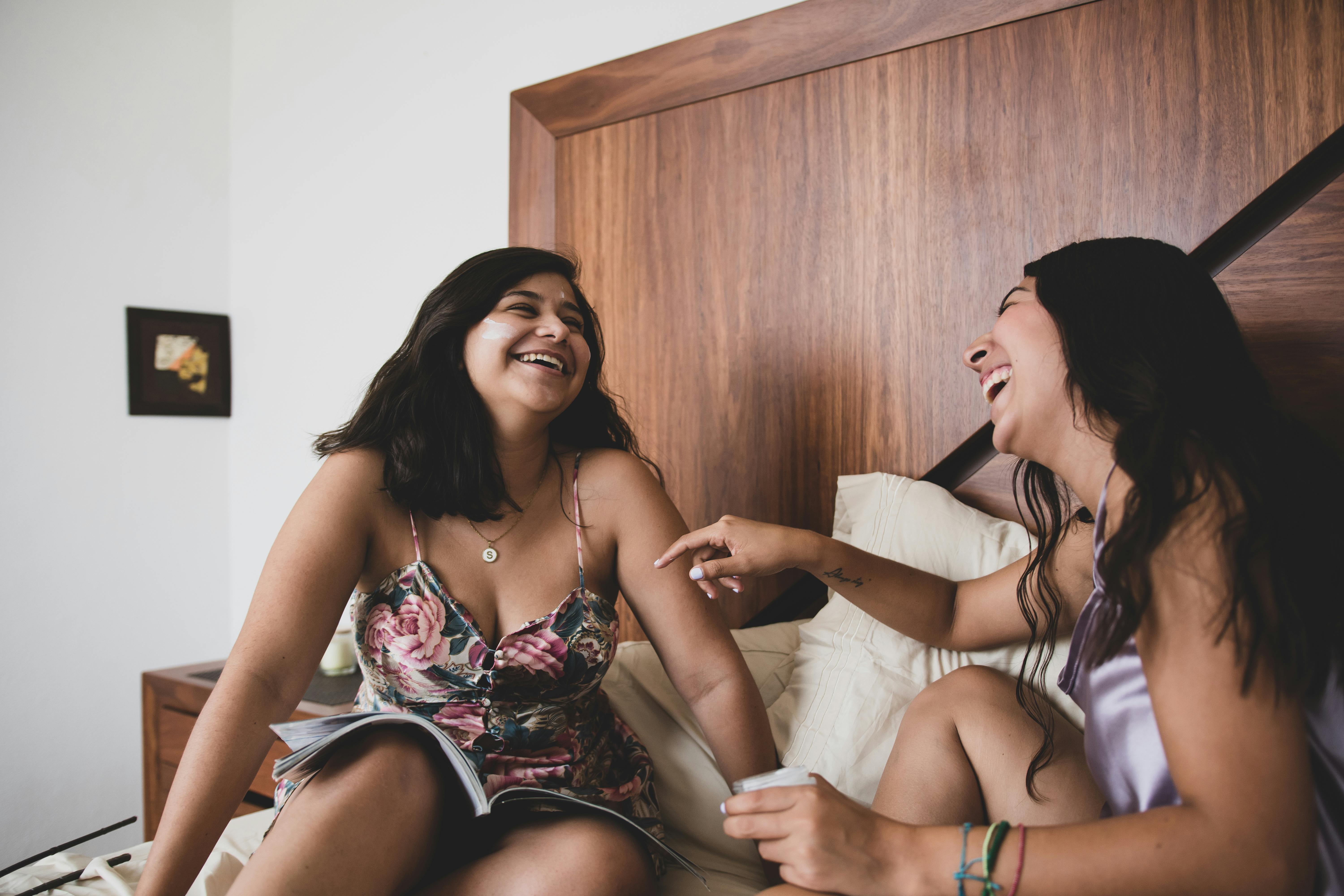 Two women laughing on the bed | Source: Pexels