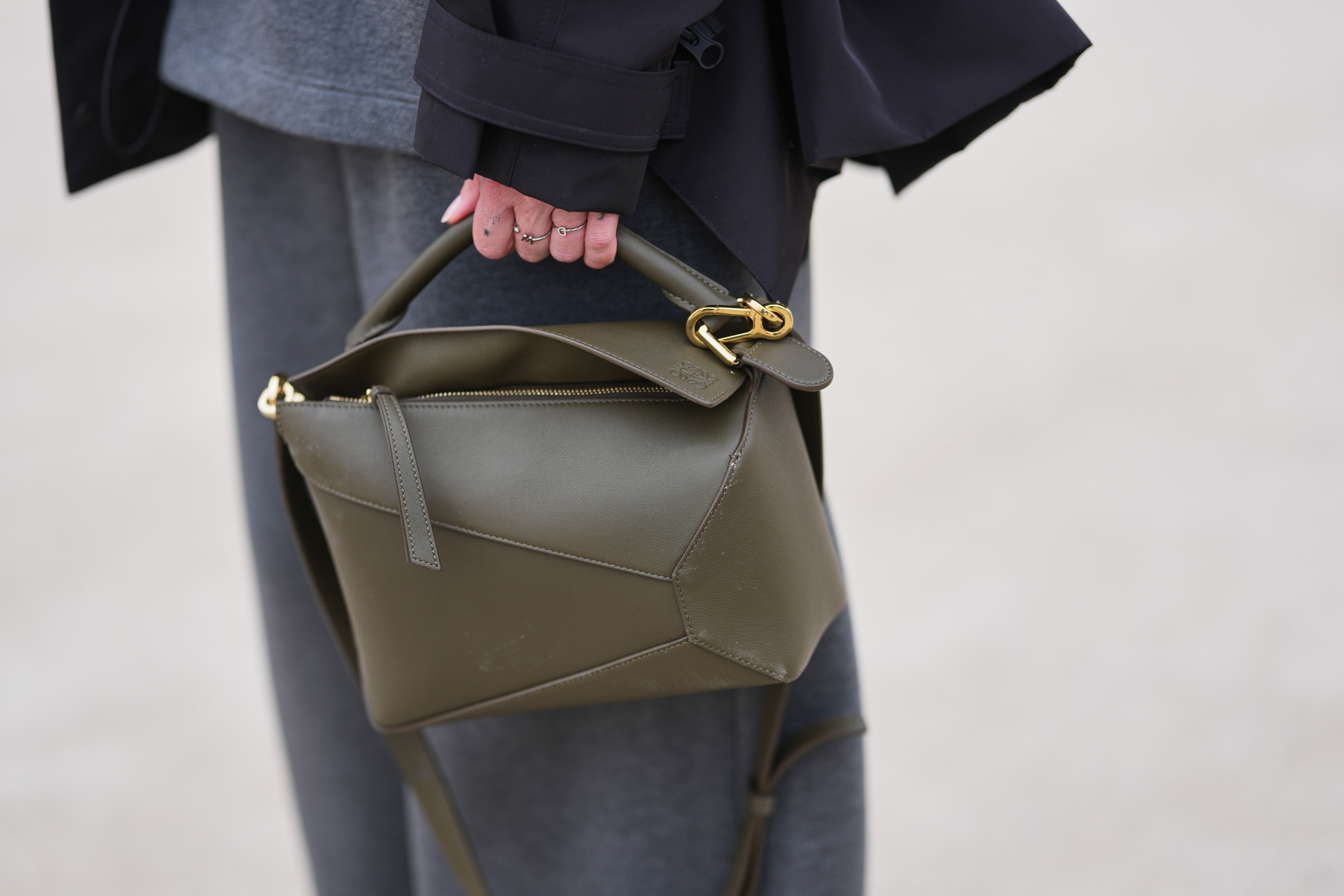 A guest wears a green leather Puzzle handbag from Loewe, outside Loewe, during Paris Fashion Week - Womenswear Fall/Winter 2026/2027, on March 06, 2026 in Paris, France. | Source: Getty Images