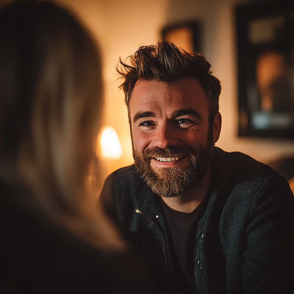 A smiling man talking to a woman in her living room | Source: Midjourney