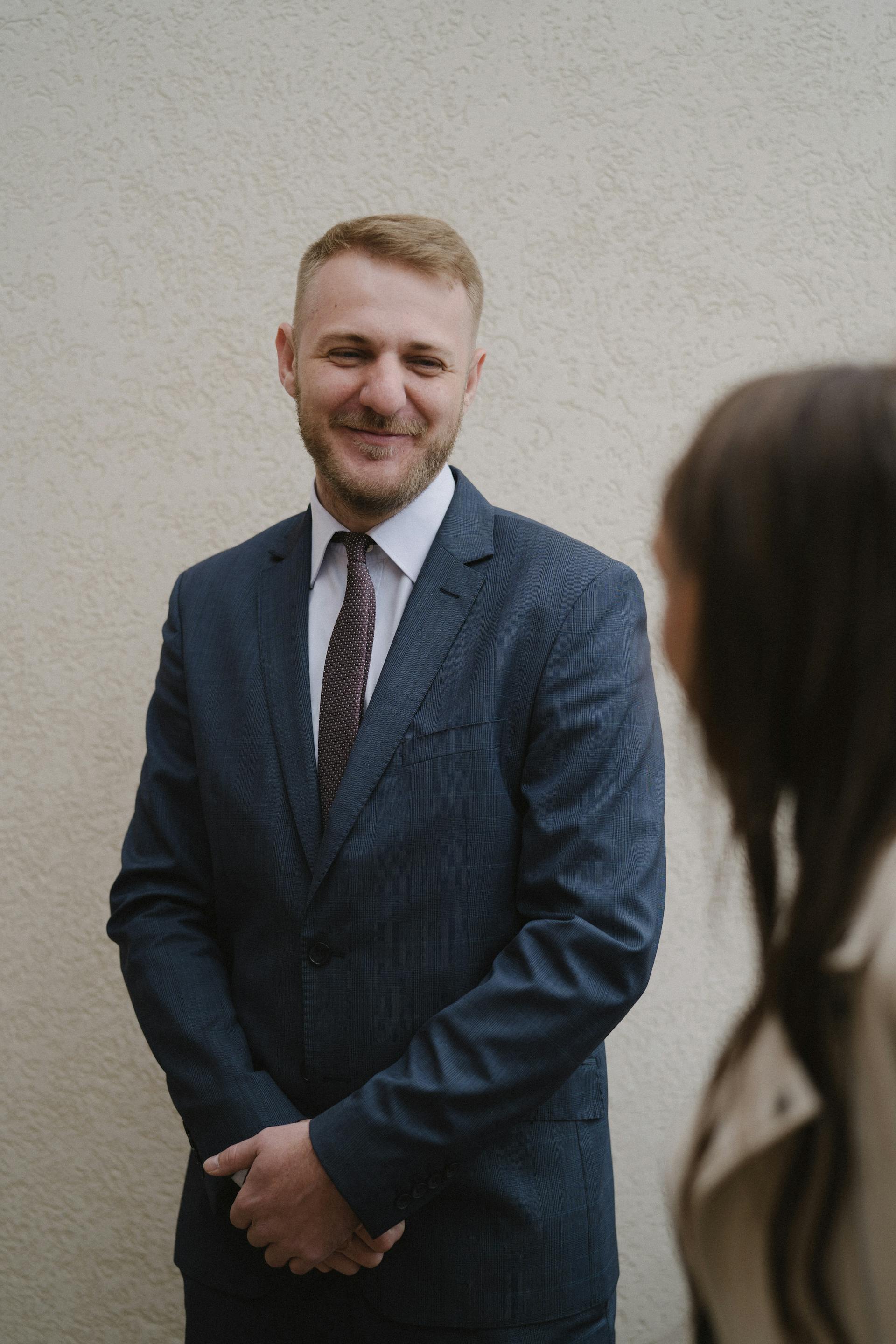 A man in a fancy suit smirking at a woman | Source: Pexels