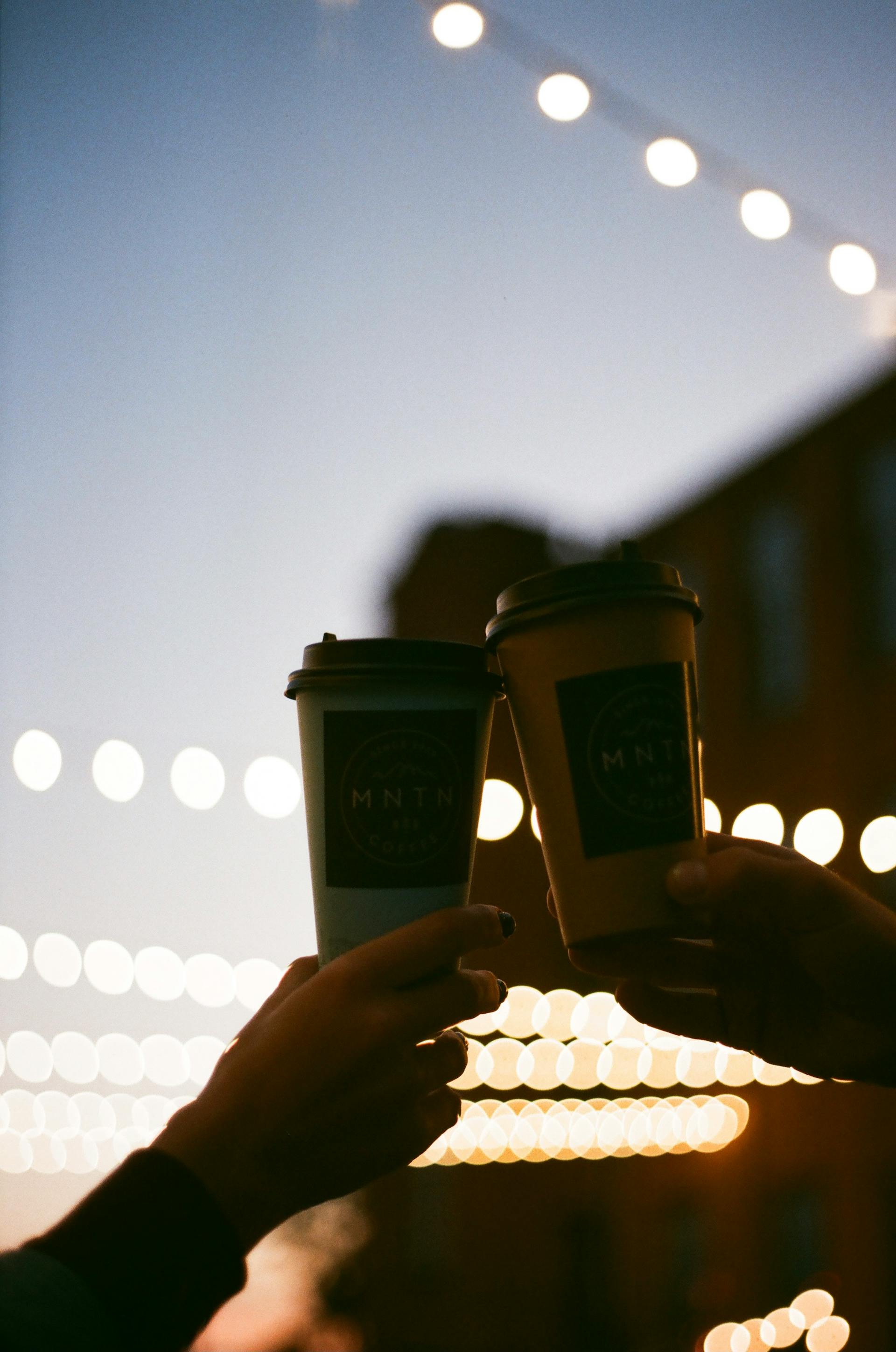 Two hands holding coffee cups | Source: Pexels