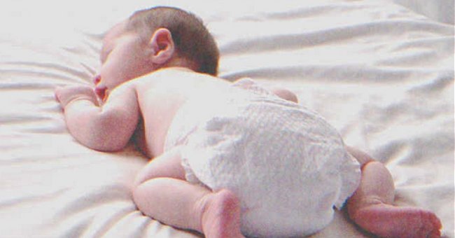 A baby laying on a bed | Source: Shutterstock