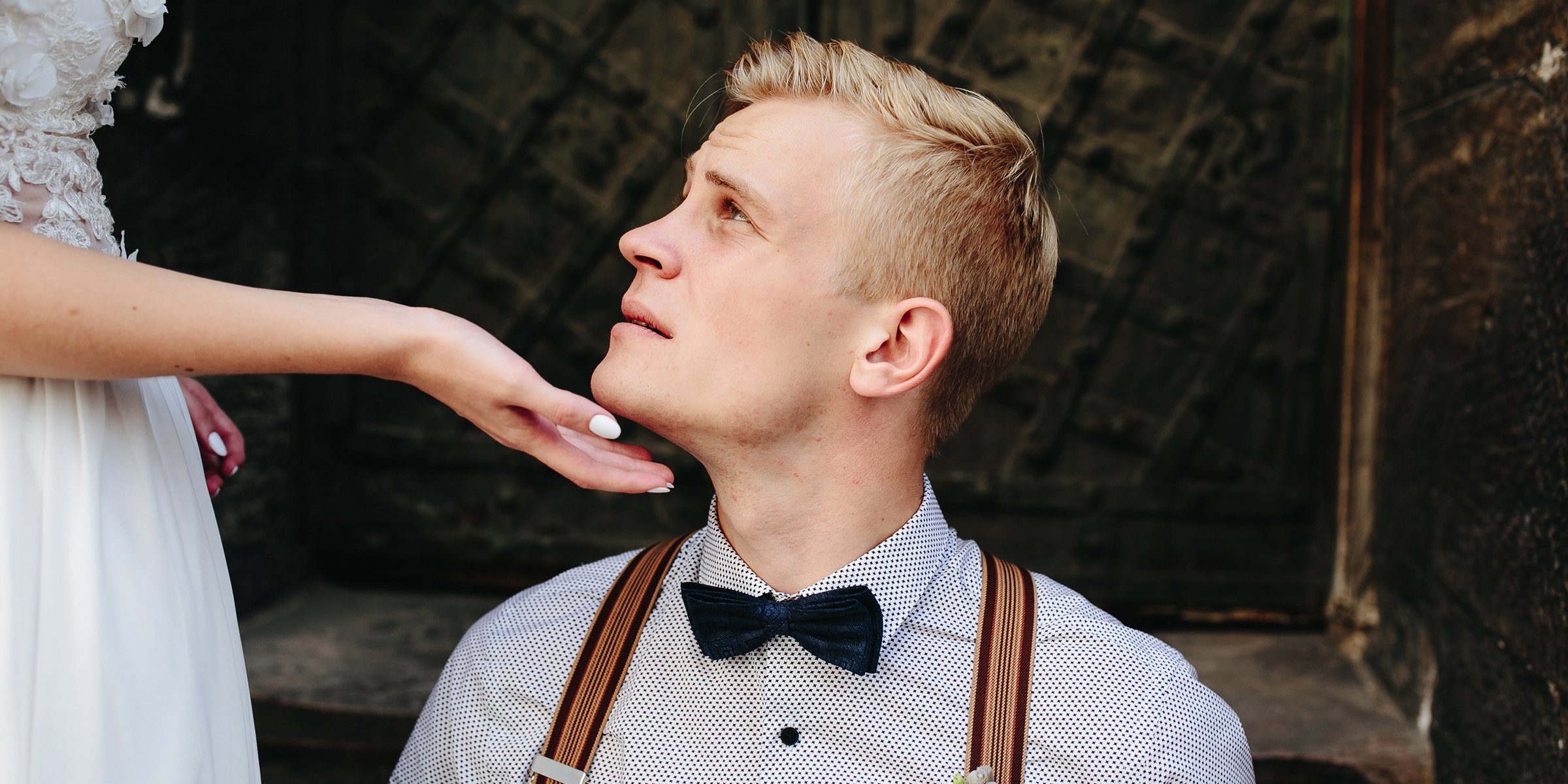 A woman's hand cupping a man's chin as he looks up at her | Source: Shutterstock