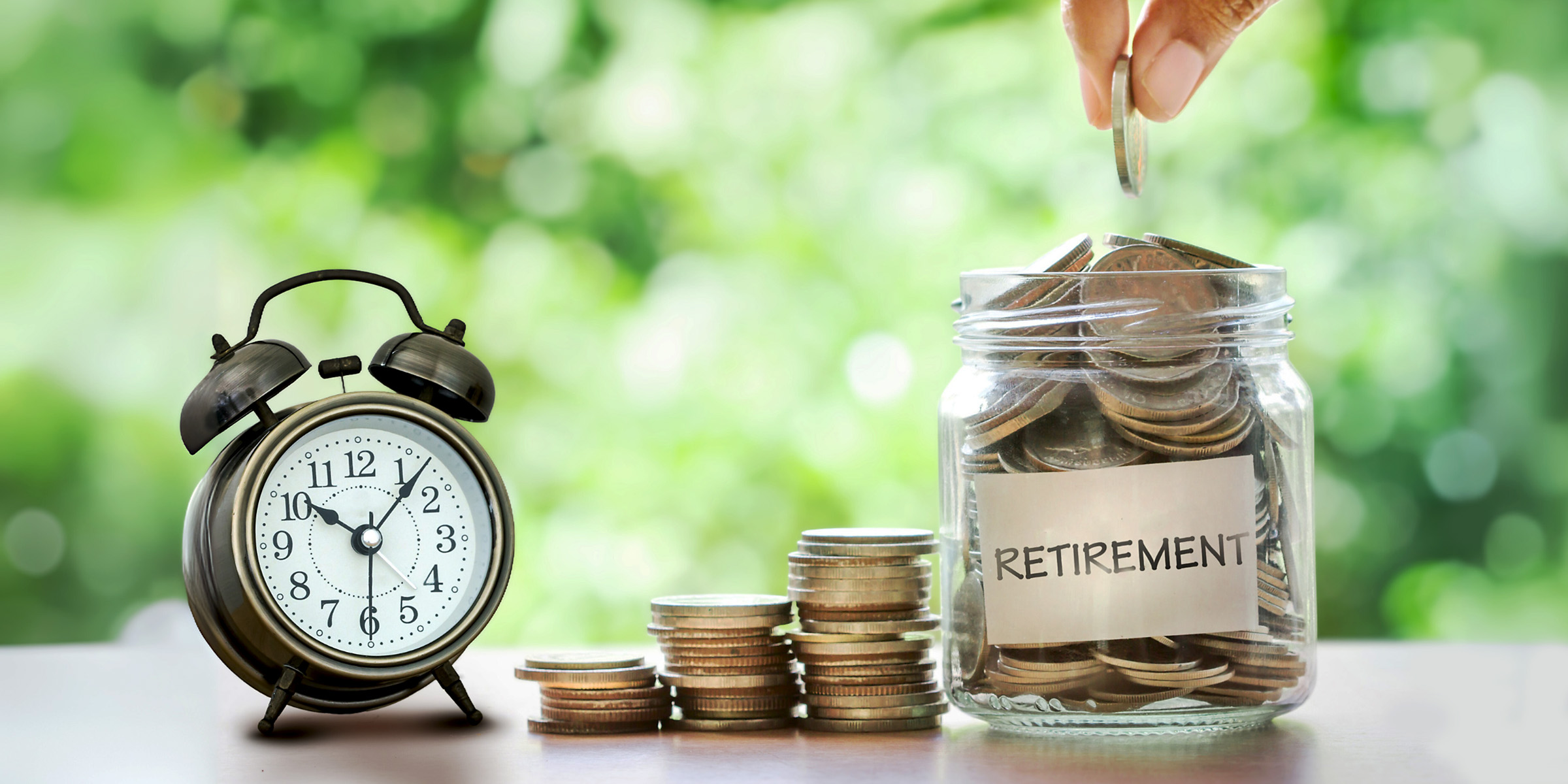 A person adding coins to a jar | Source: Shutterstock