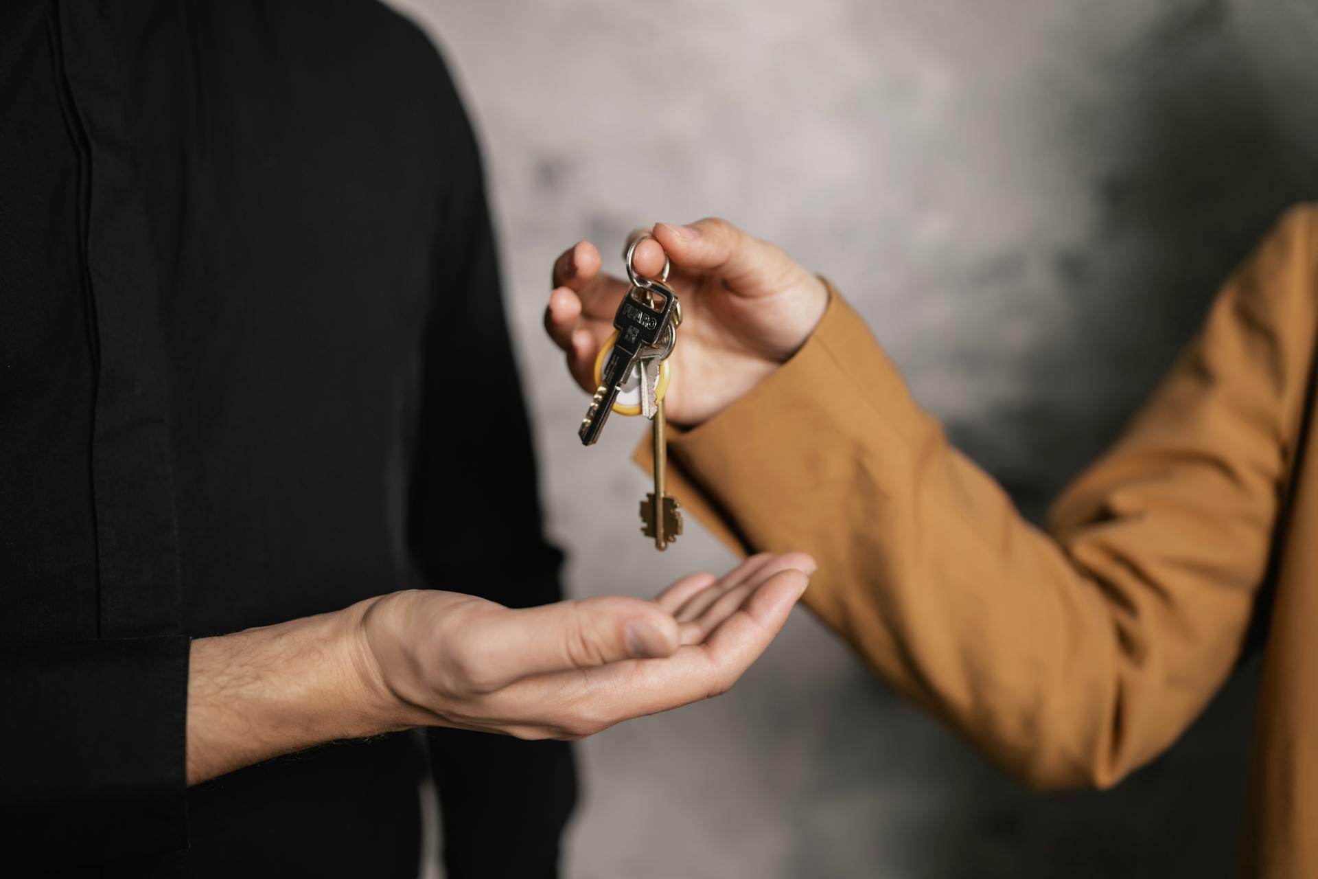 A person giving a bundle of keys to another person | Source: Pexels