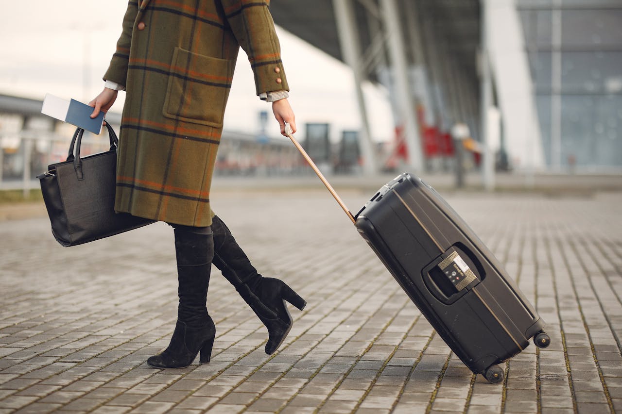 A woman with a suitcase and bag | Source: Pexels