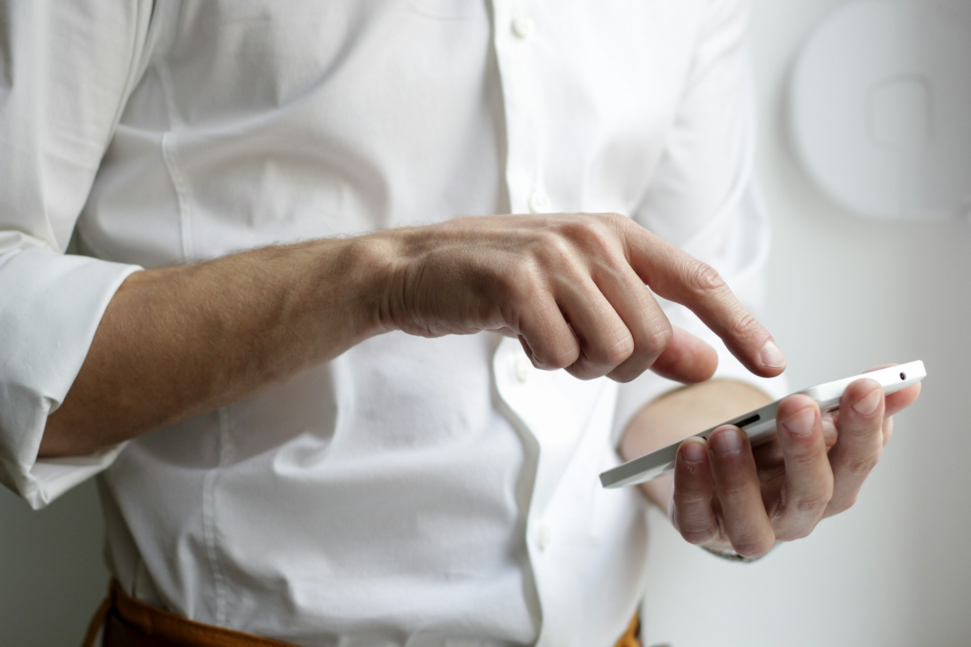 Foto recortada de um homem segurando seu telefone | Fonte: Unsplash