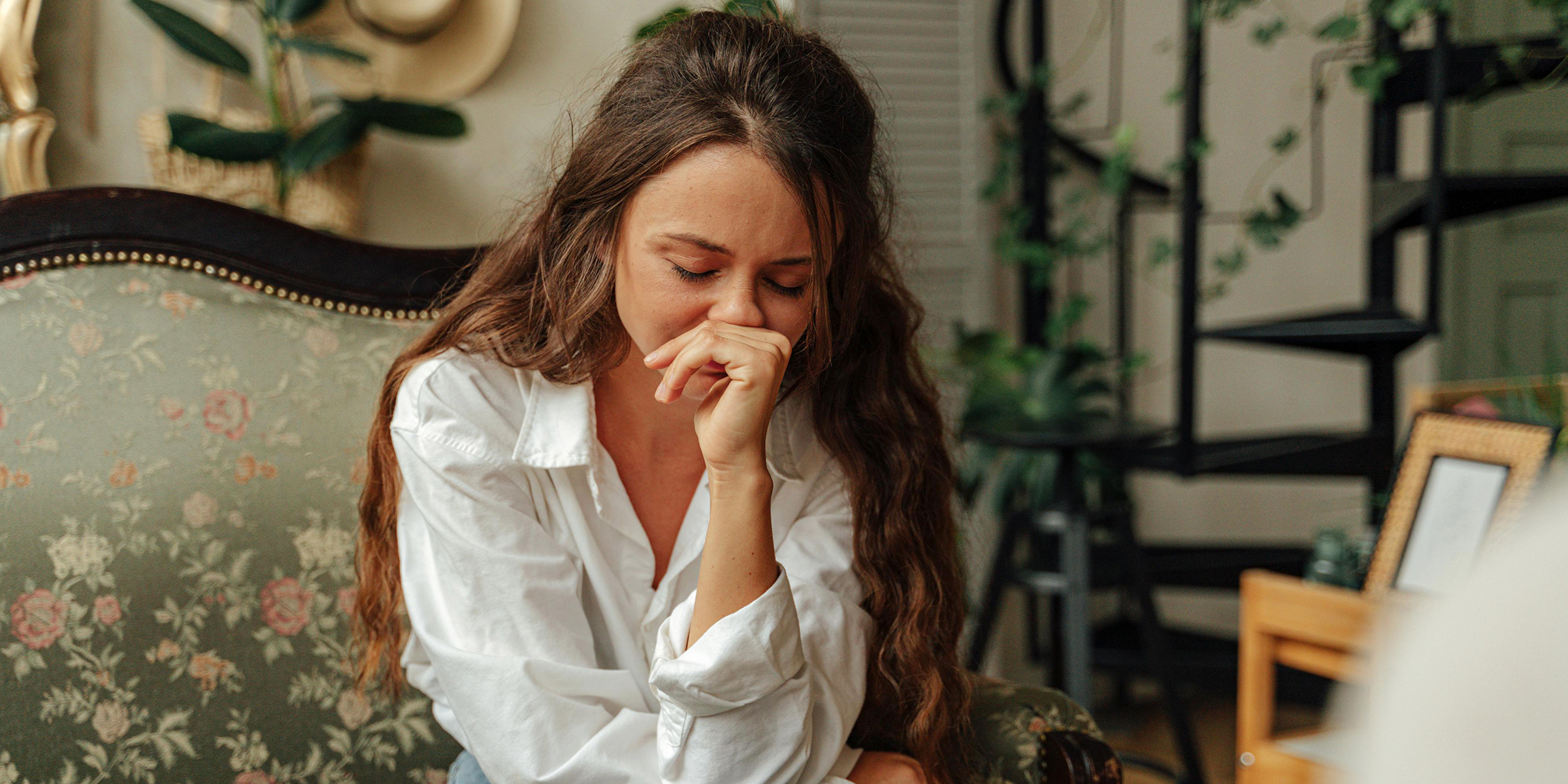 Frustrated woman sitting on the sofa | Source: Sora