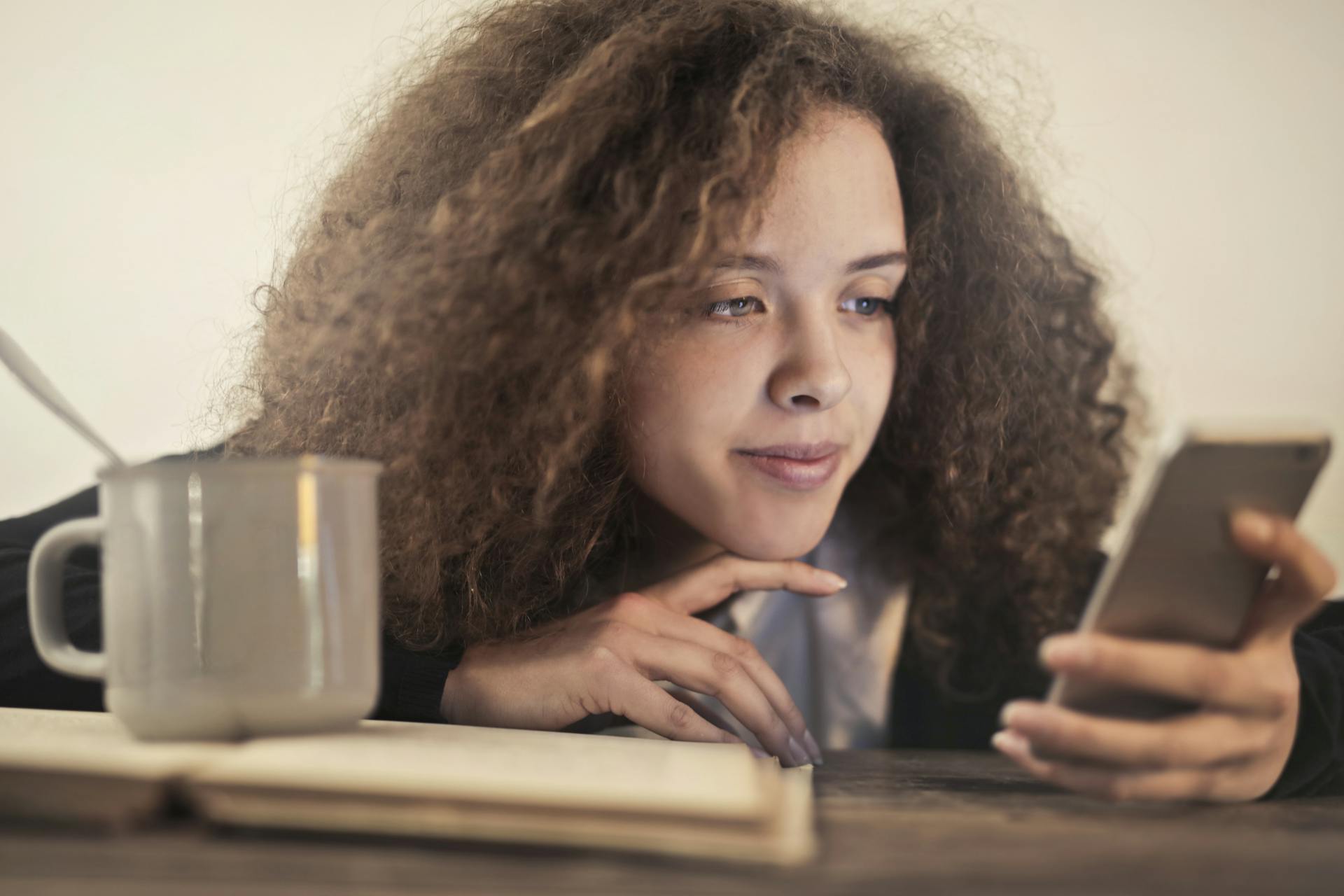 Uma mulher olhando para a tela de um celular | Fonte: Pexels