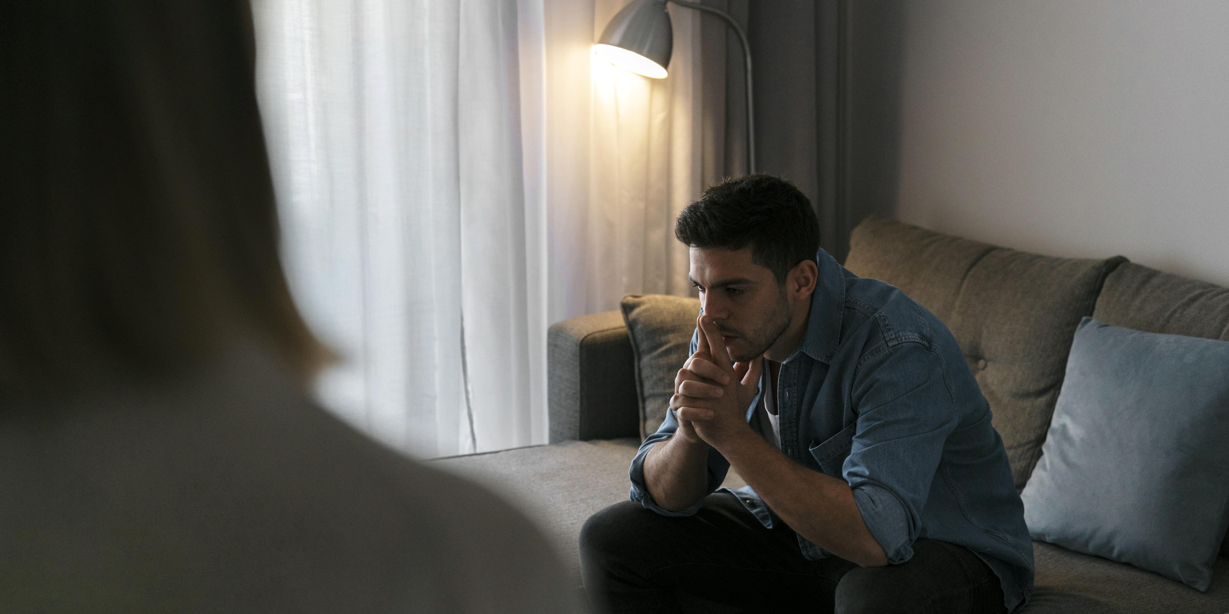 An emotional man sitting on a sofa | Source: Freepik