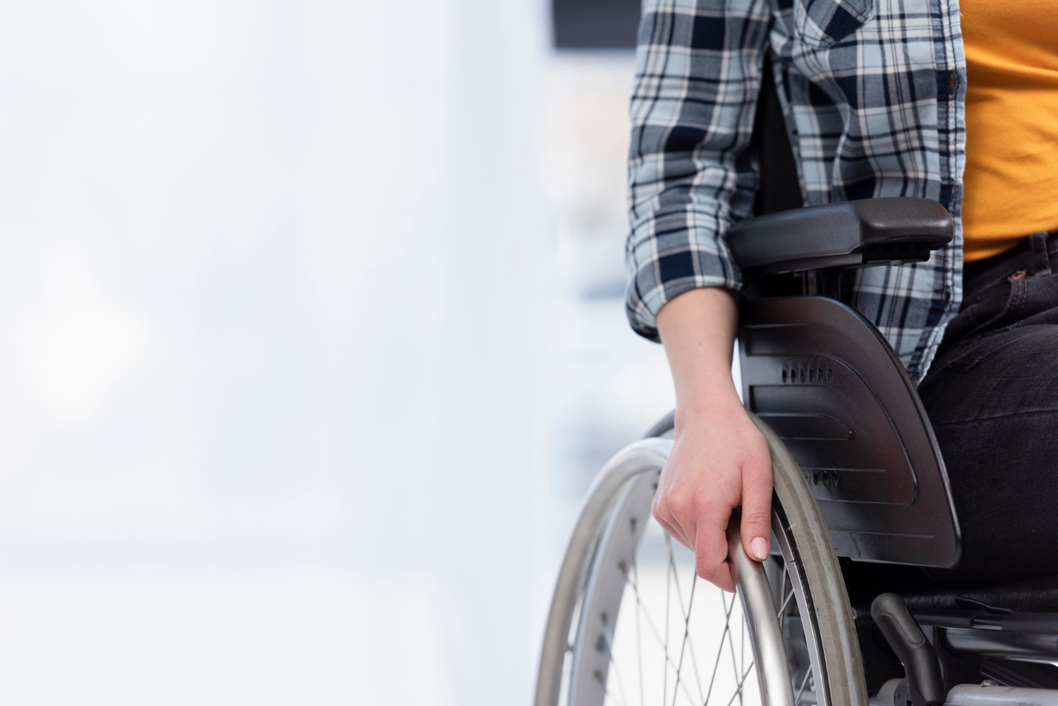 Cropped shot of a woman sitting on her wheelchair | Source: Freepik